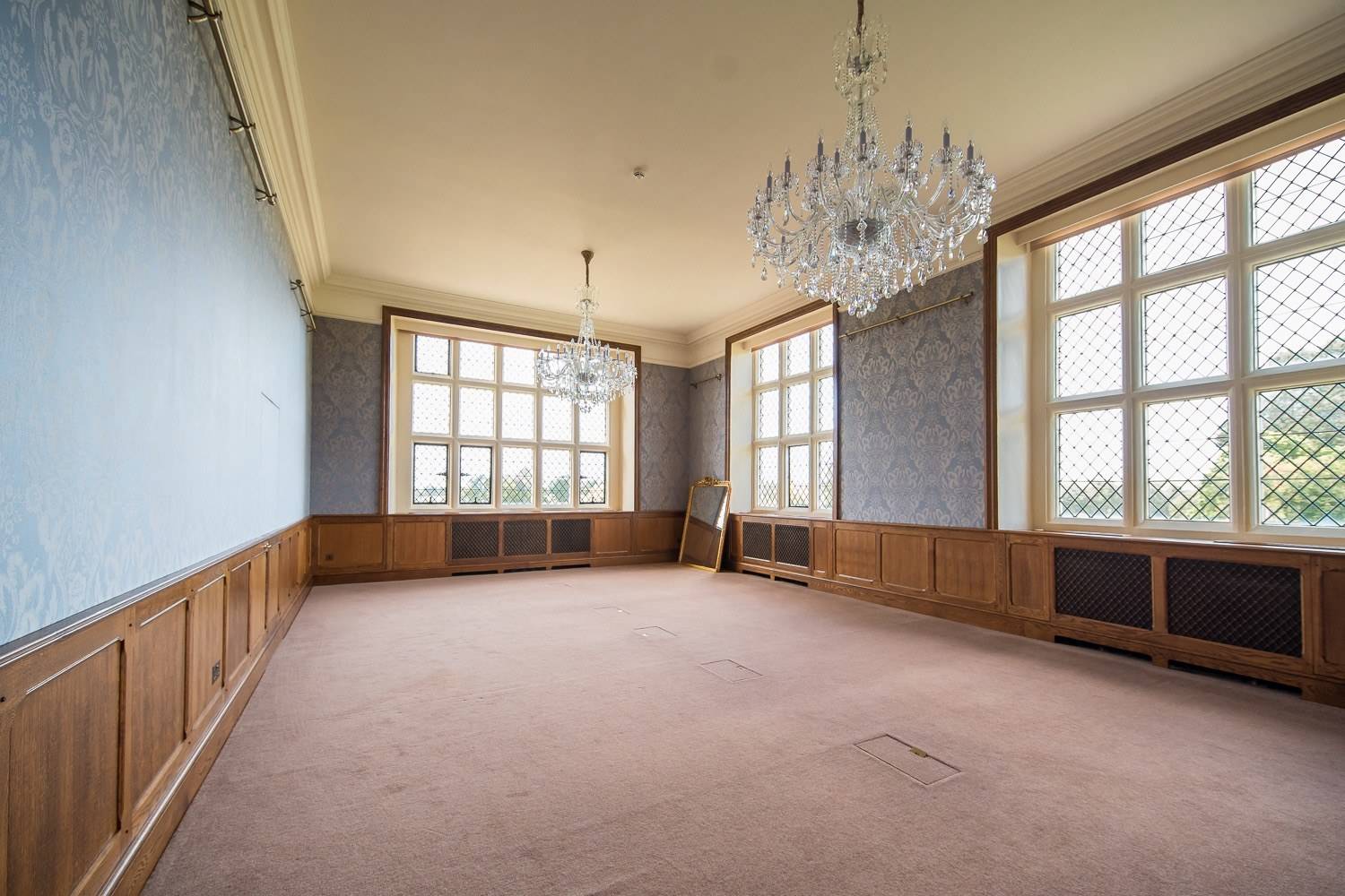 Light-filled period reception room shoot space with floral wallpaper, crystal chandelier, and oak dado panelling via Love Locations.