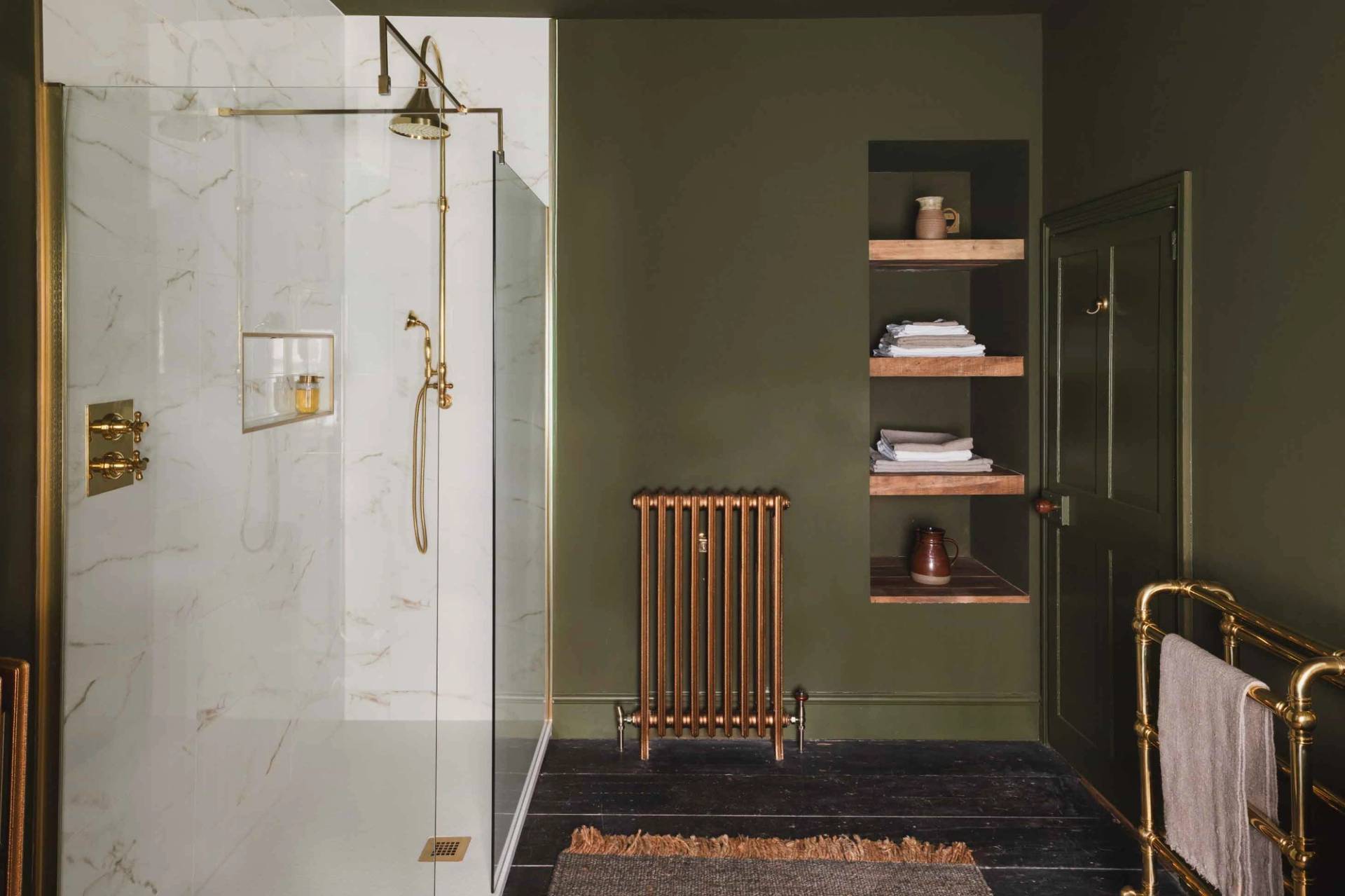 Modern walk-in shower with gold fixtures and green tile accents in a Grade II-listed Newquay home via Love Locations.
