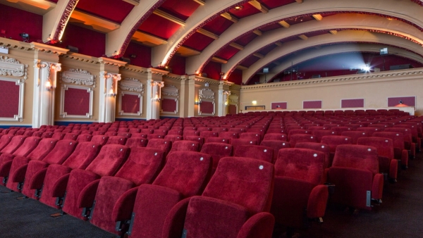 Looking up from the front row seats toward the tiered auditorium seating and ornate vaulted ceiling details inside The Ritzy Screen 1 via Love Locations.