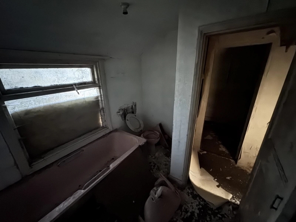 Dark, atmospheric derelict bathroom with an old pink bath and toilet, ideal for suspenseful thriller filming in Nottingham, via Love Locations.
