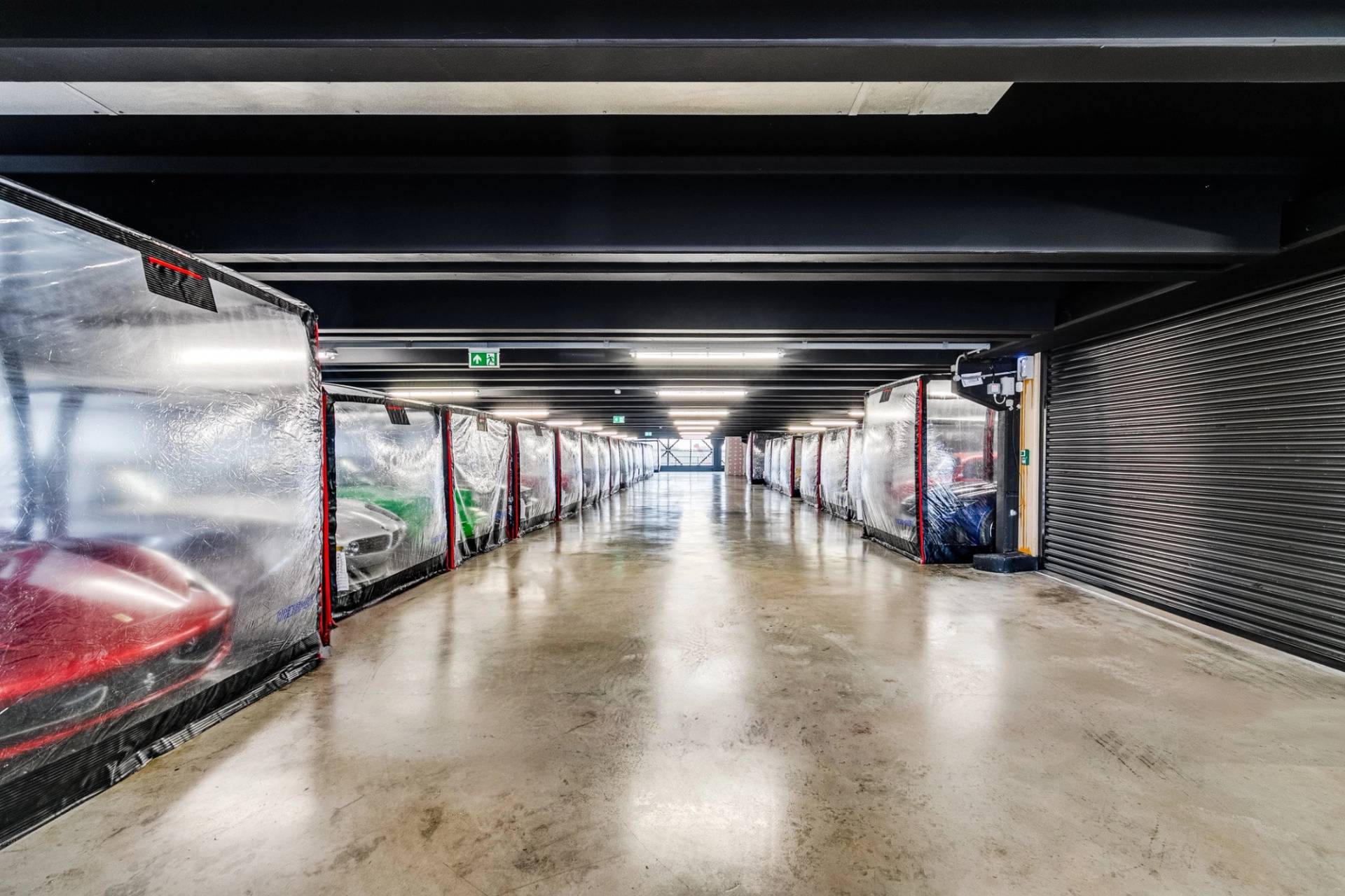 Symmetrical perspective down a car storage facility with concrete floors in Brentford TW8 via Love Locations.