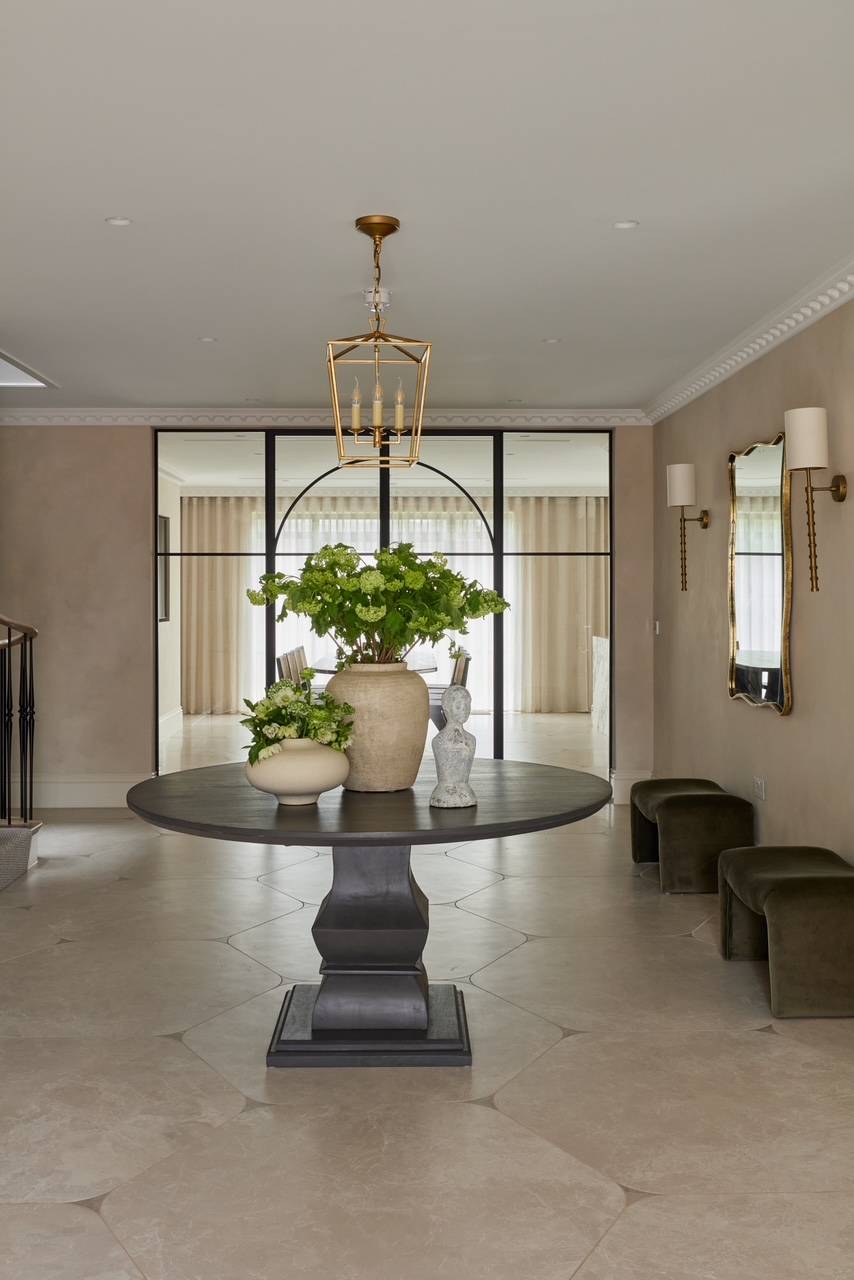 Grand entrance hall location in Hertfordshire showcasing a round central presentation table under a statement brass chandelier, excellent for period film productions, Love Locations.