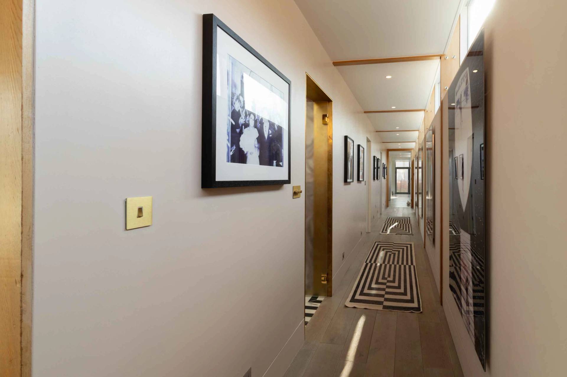 Love Locations minimalist gallery hallway Godalming: Long residential corridor displaying large framed black-and-white photography, ideal for smooth camera walking tracking shots.