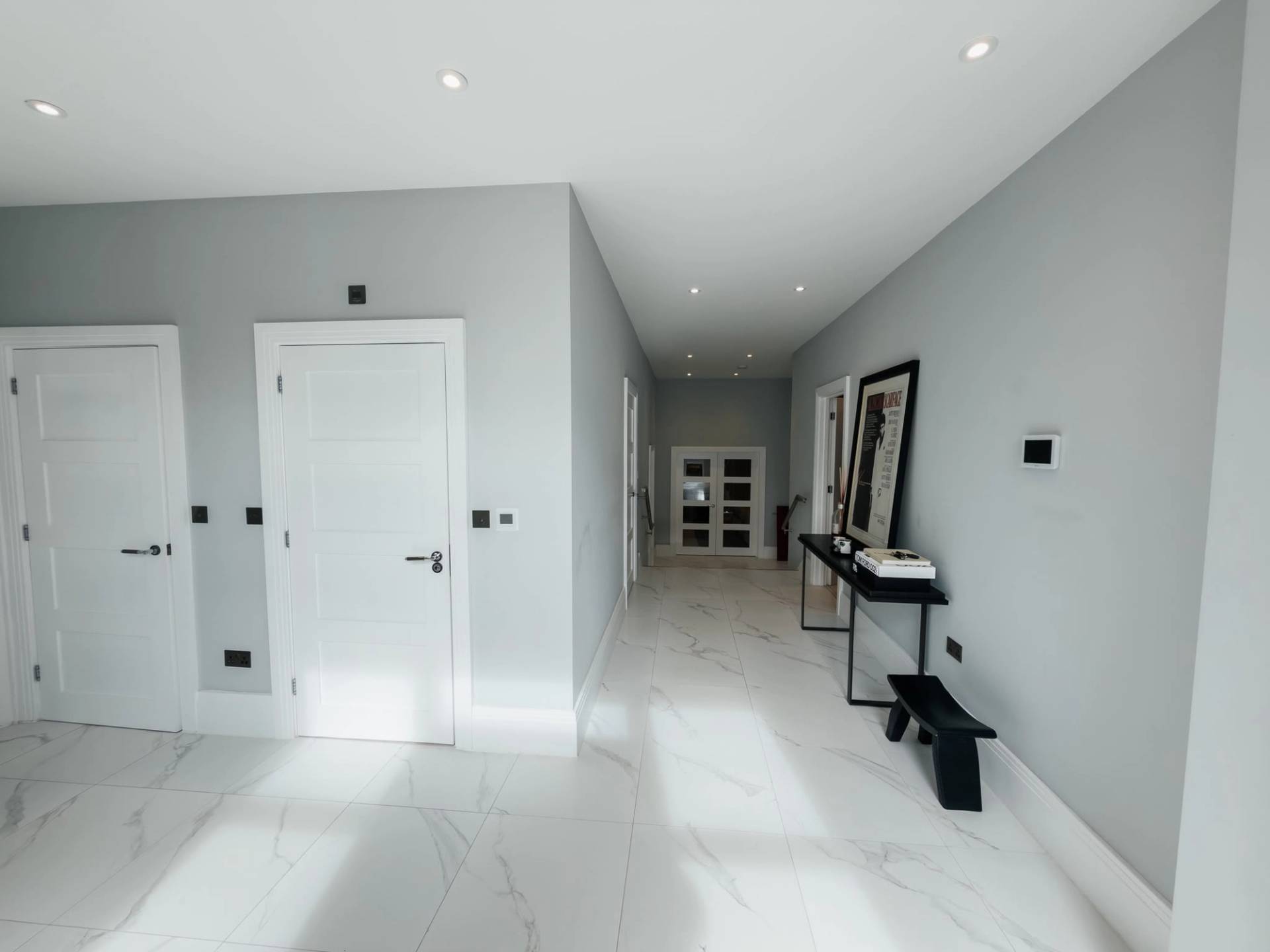 Minimalist white kitchen island and dining area shoot space in Barnet EN4 from Love Locations, featuring bright ceiling spotlights and marble tile flooring.