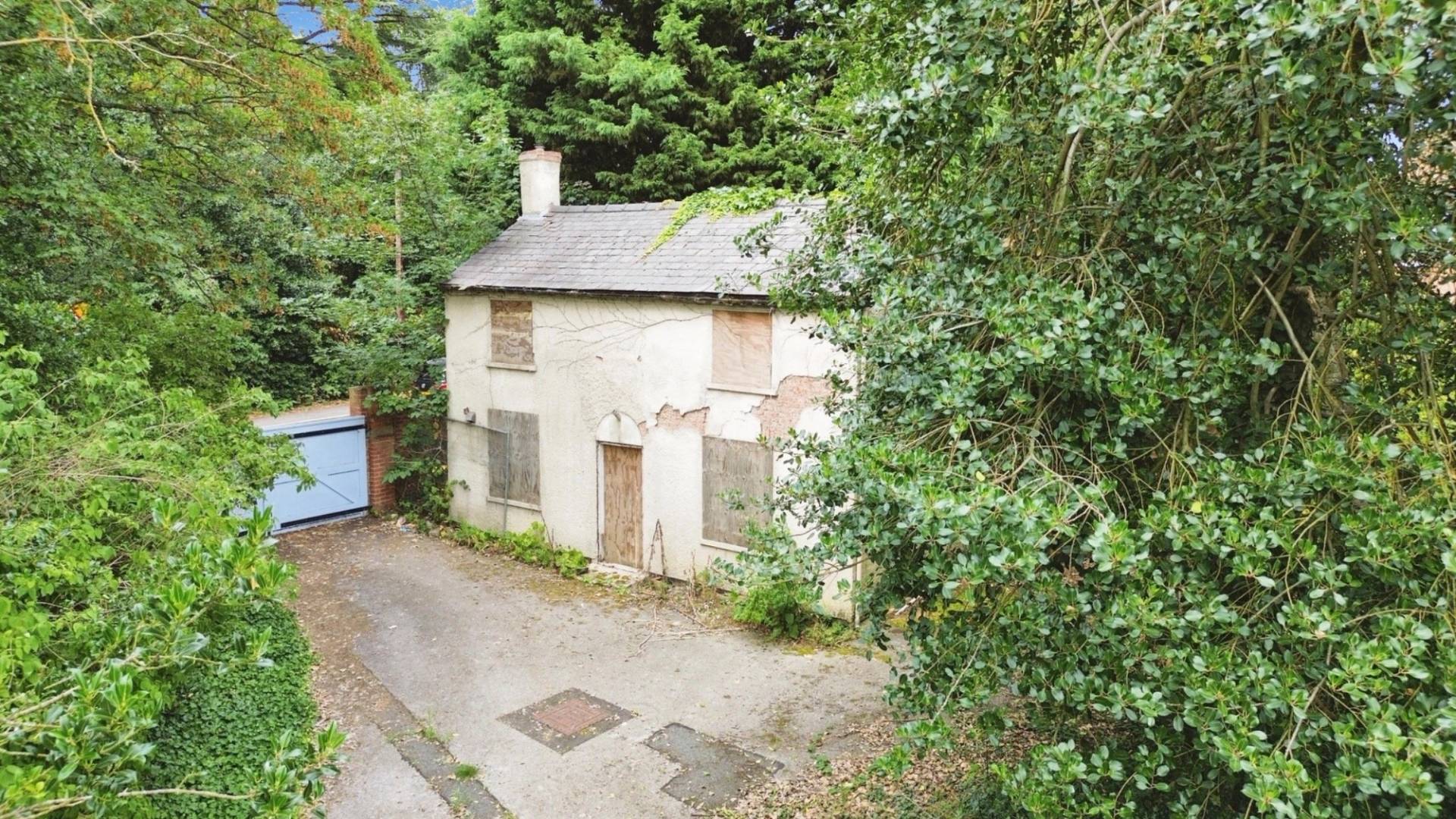 High-angle view of a derelict cottage set back on an overgrown plot, a secluded and spooky filming location via Love Locations.
