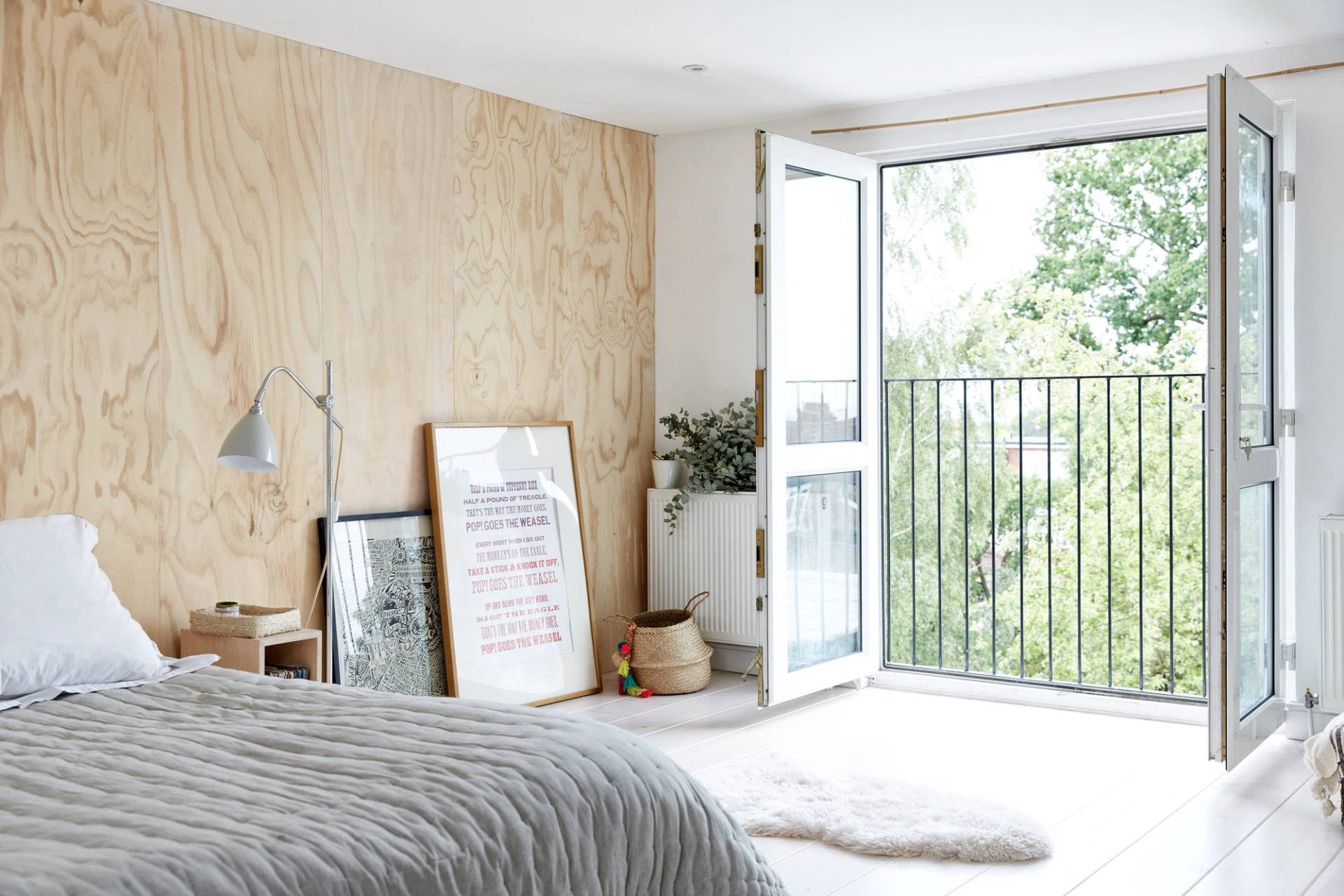 Plywood-panelled bedroom suite featuring double doors opening onto a Juliet balcony with garden views, Love Locations N13.