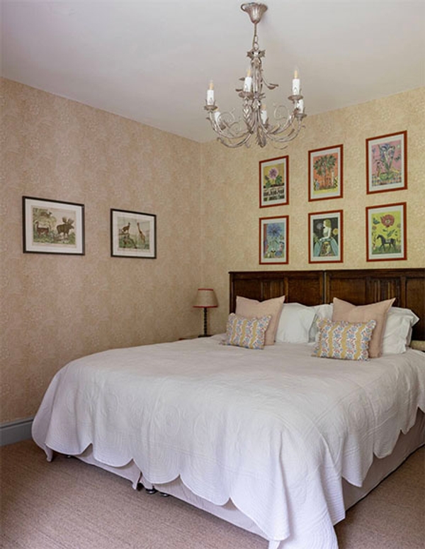 Glenstriven guest bedroom with chandelier, double bed and framed artwork above headboard.