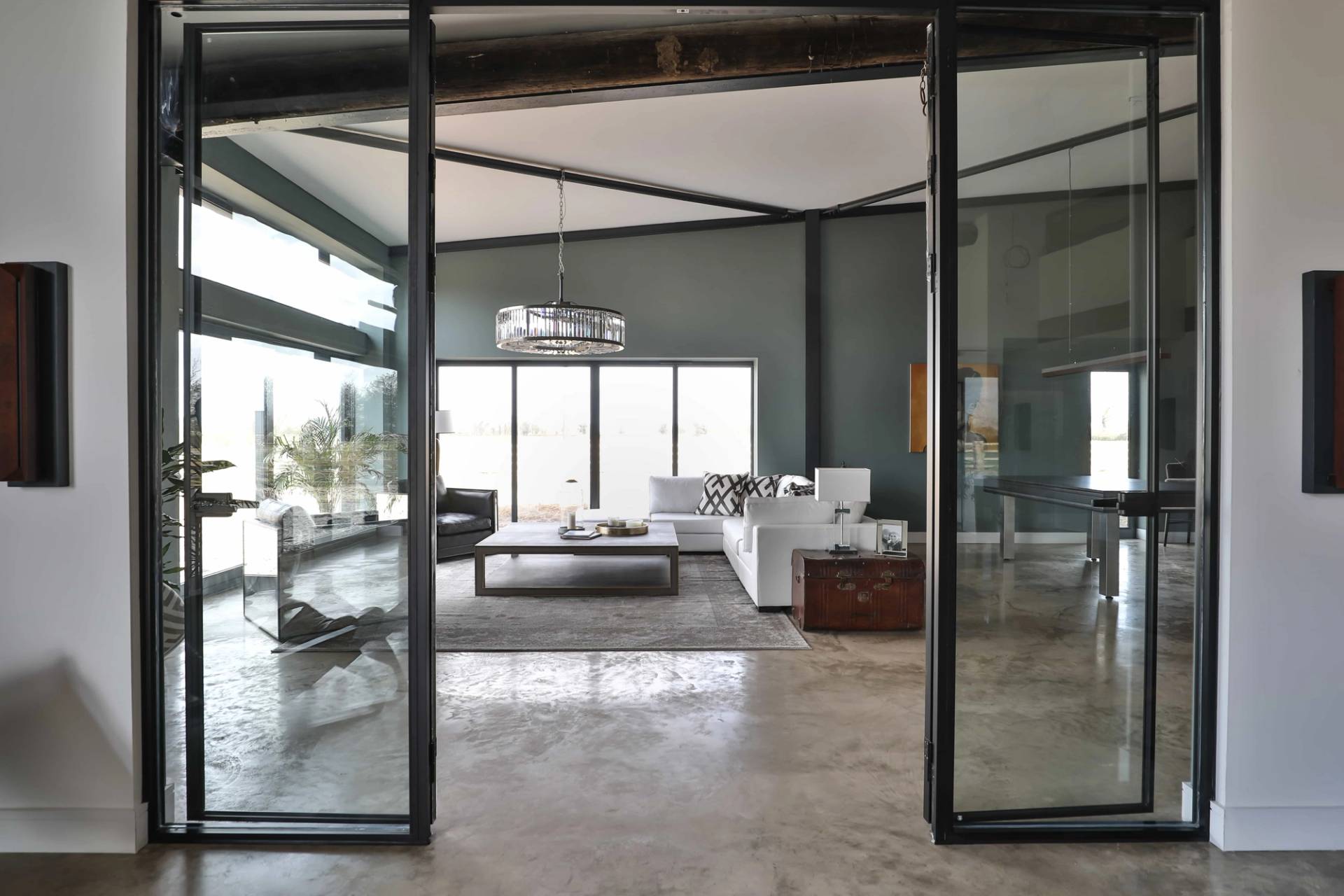 Glass sliding Crittall doors opening into a double-height entrance hall and lounge space, Love Locations CV23.