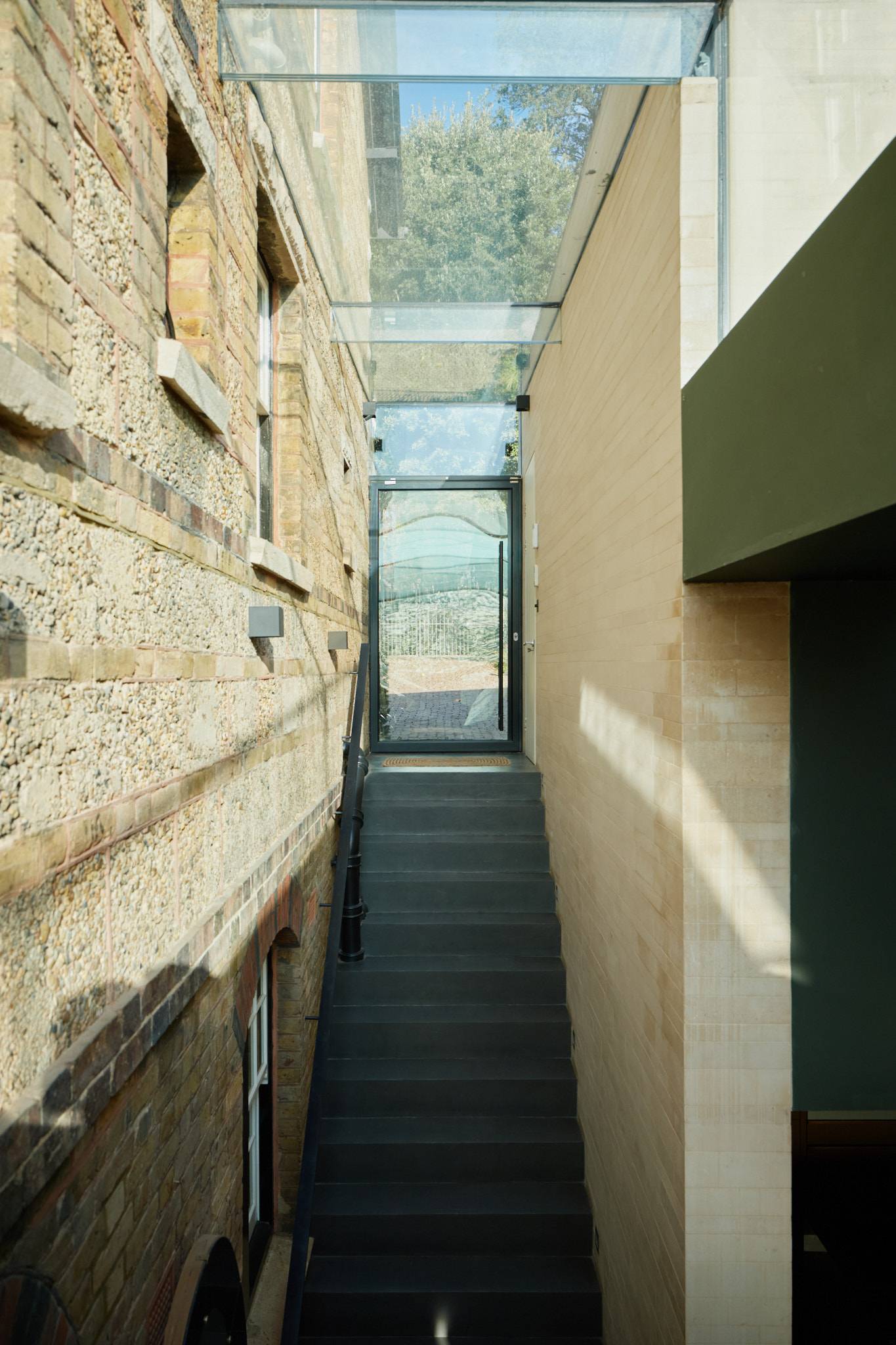 Glass ceiling lightwell walkway positioned between historic brick walls and a modern residential extension, ideal for architectural filming, Love Locations.