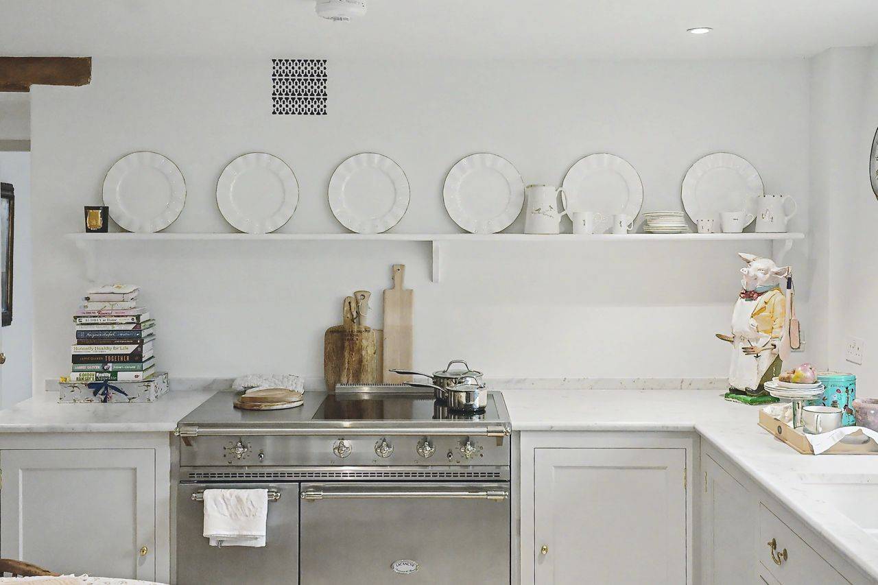 Detail of a classic range cooker and kitchen shelving unit photoshoot setting in Gloucestershire GL7 from Love Locations, featuring white ceramic dishware.