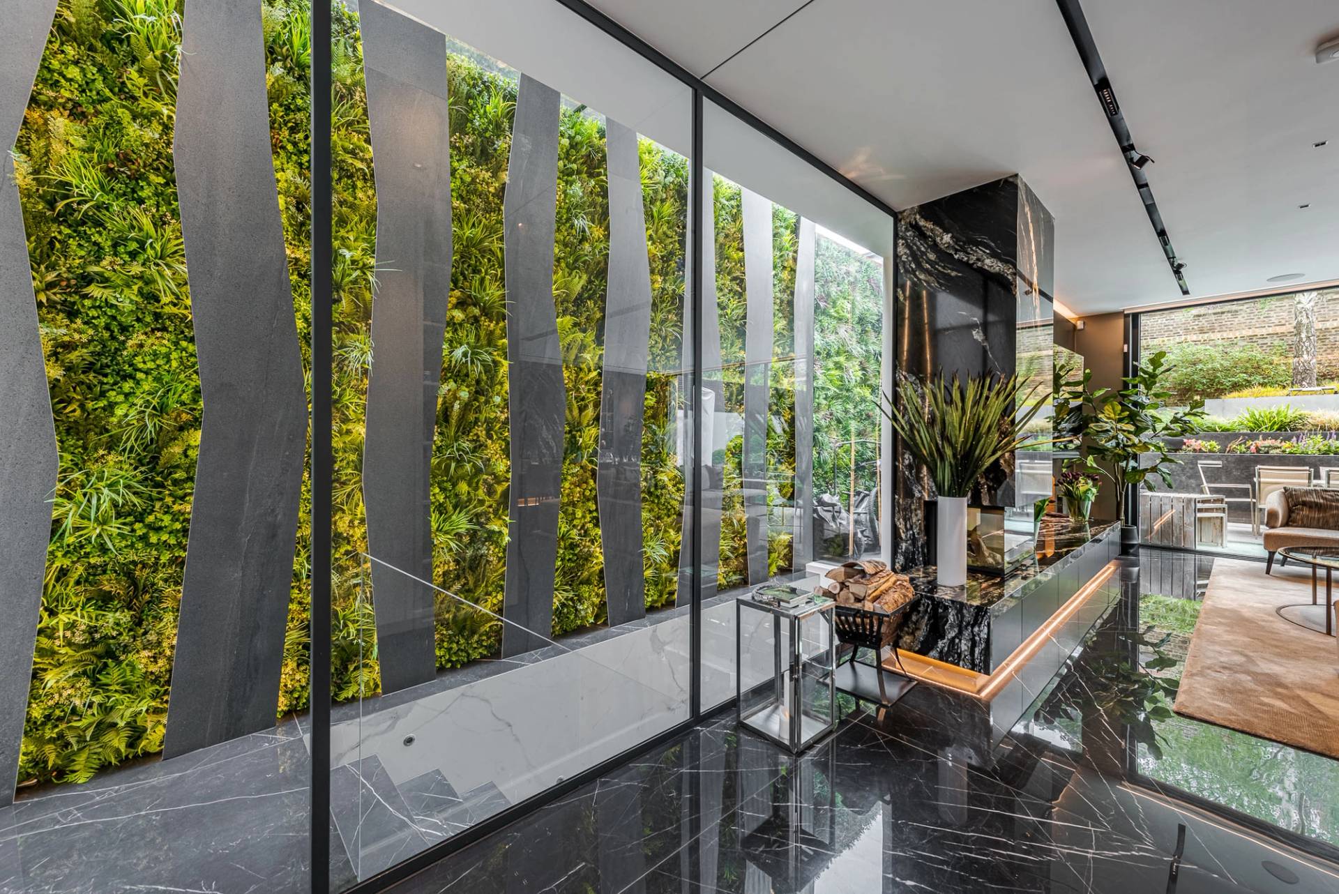 Living plant wall paneling set in a modern hallway with black polished marble tiles, Love Locations SW11.