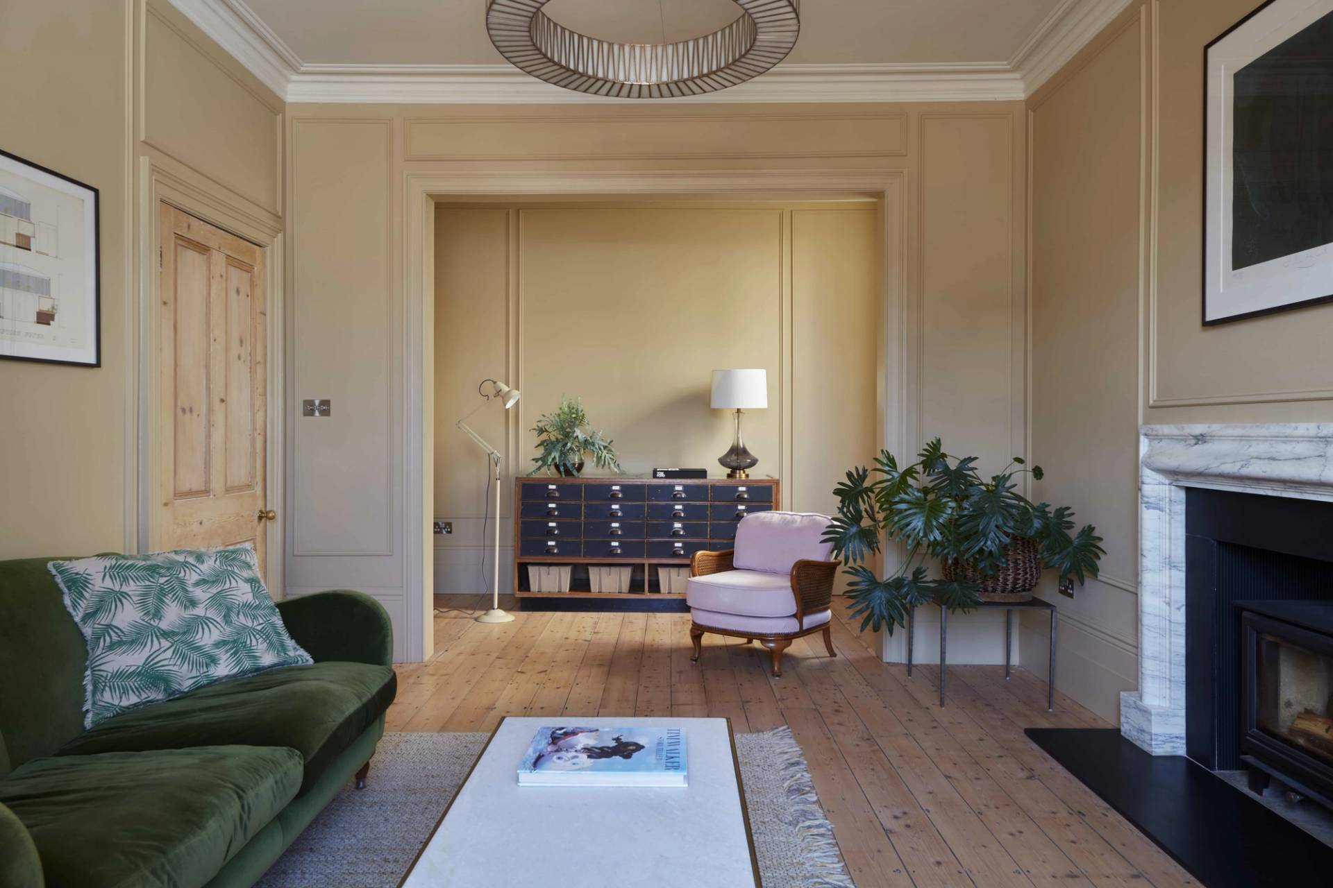 Period living room view with ochre walls, antique drawers, and potted plants in a Hastings location home, Love Locations TN34.