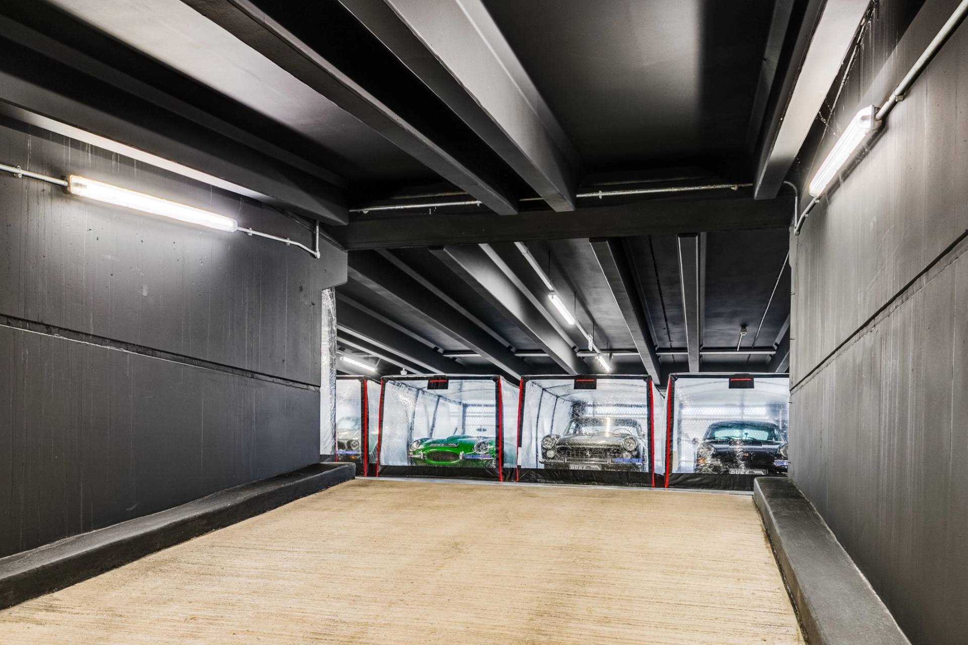 Empty modern car storage bay with dark industrial ceilings in Brentford TW8 by Love Locations.