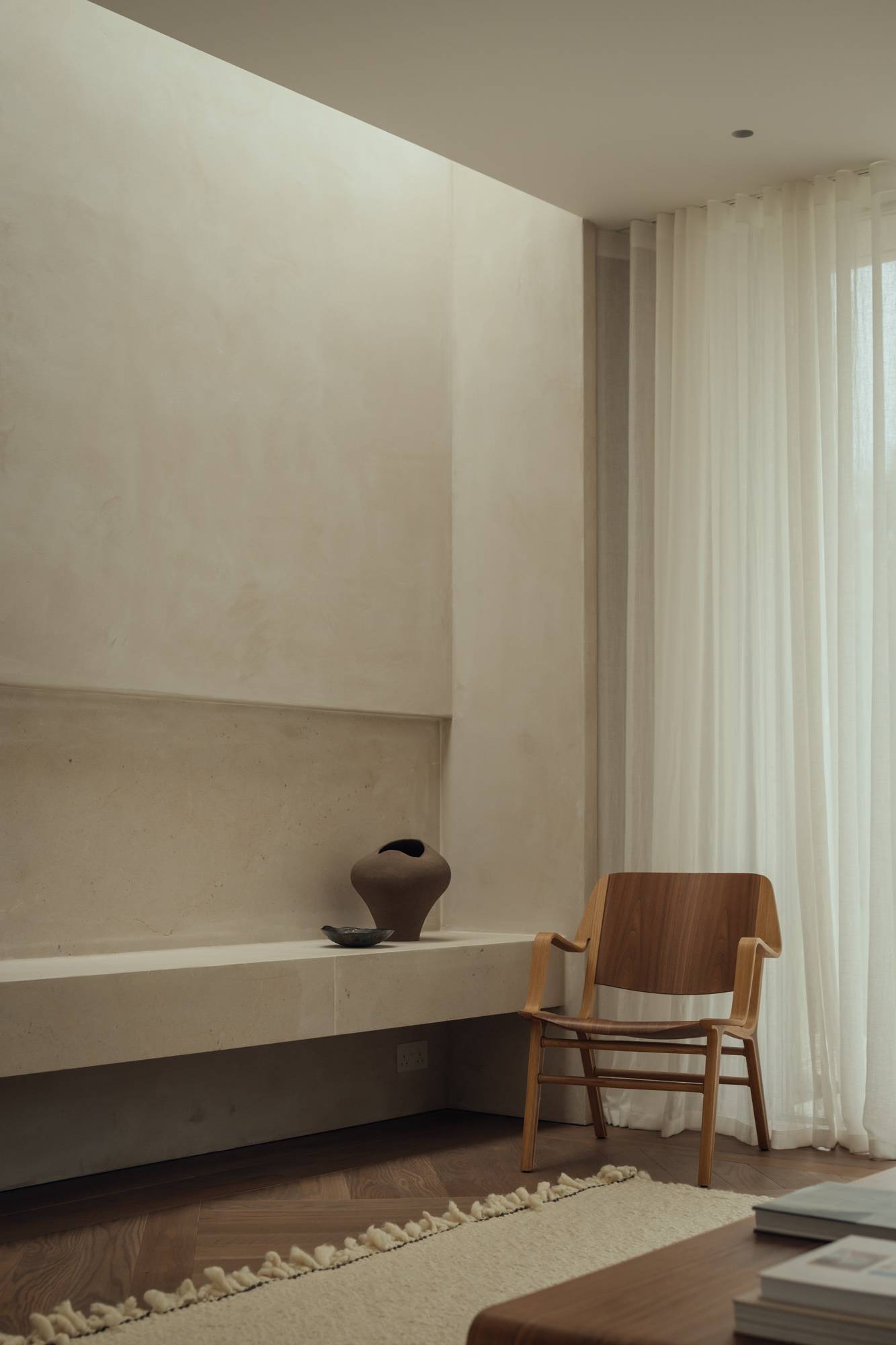 Monochromatic living room vignette showcasing a classic wooden chair set against smooth micro-cement walls, suitable for designer furniture promotions, Love Locations SO20.