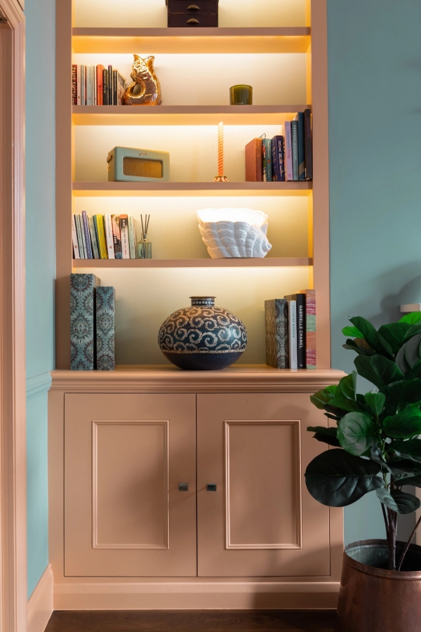 Bespoke built-in wooden alcove shelving with warm LED strip lighting in a Westminster SW1V property, curated for media production by Love Locations.