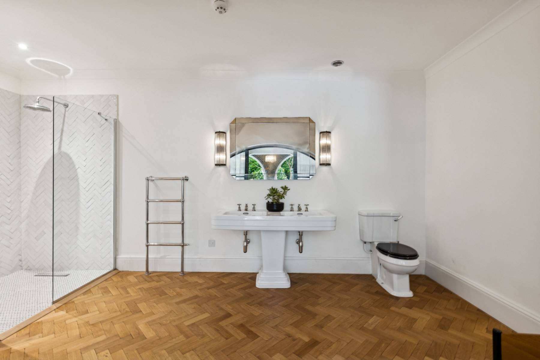 Clean white bathroom production space featuring a pedestal basin and mirror in Hampstead London through Love Locations.