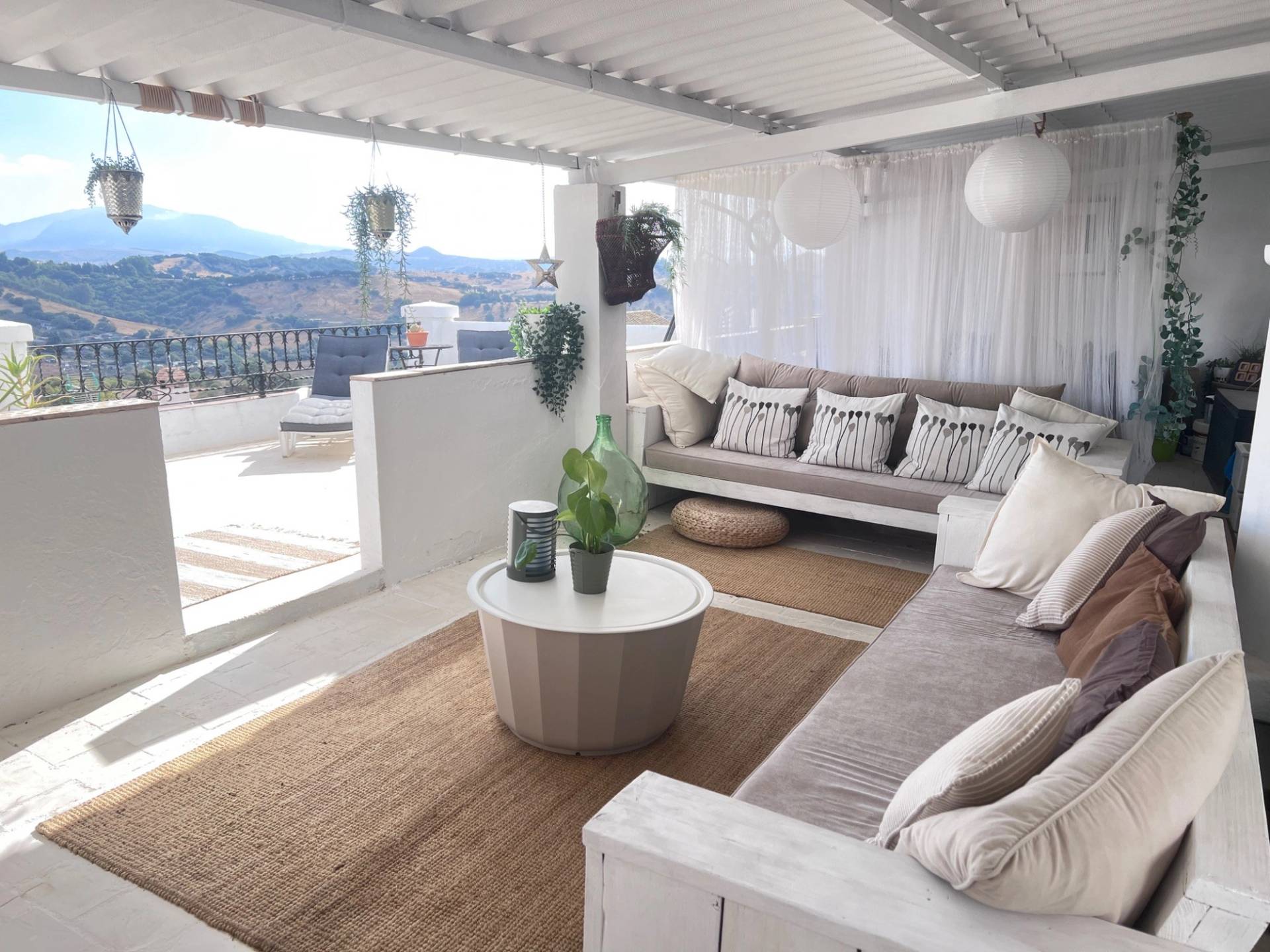 Shaded outdoor lounge terrace with low bench seating and natural jute rug in Jimena de la Frontera Cádiz available from Love Locations.