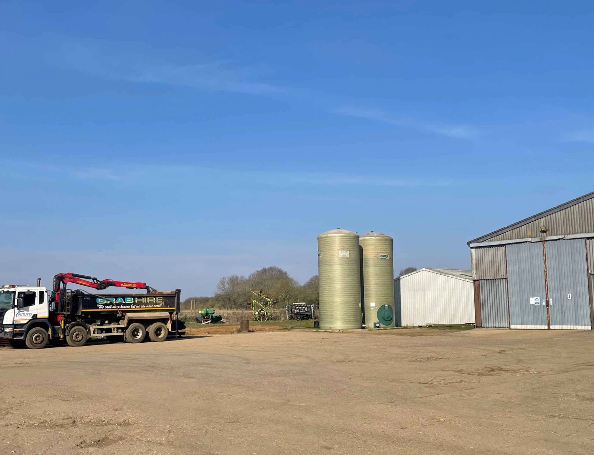 Wide farmyard and agricultural courtyard complex featuring modern sheds and outdoor working space, Love Locations.