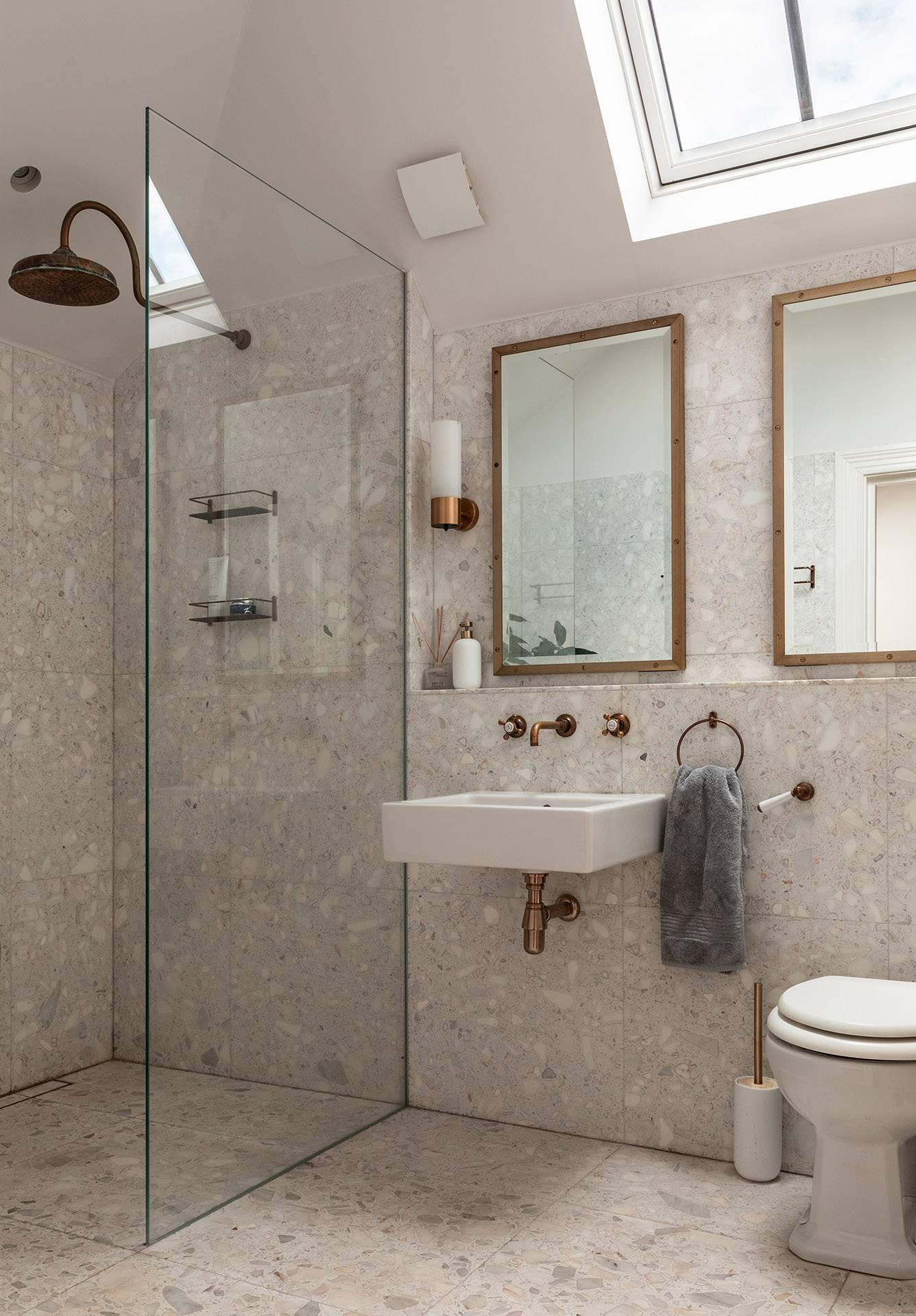 Modern walk-in terrazzo shower room with brass fixtures and glass screen partition, perfect for wellness product filming, Love Locations TW1.