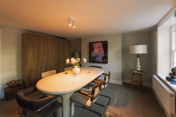 Warmly lit contemporary dining room location featuring an oval table and modern seating, perfect for family food commercials, Love Locations SW9.