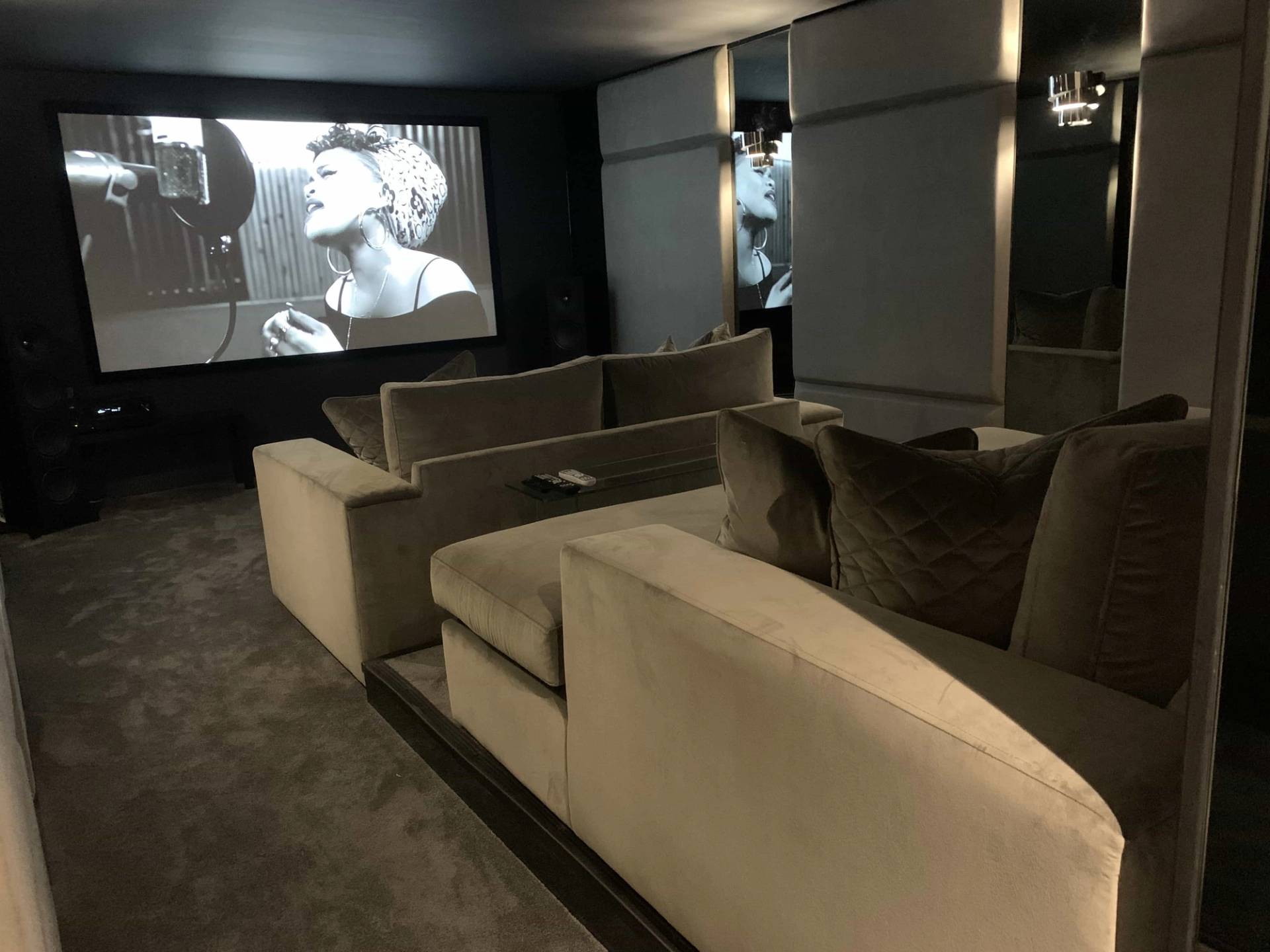 Private home cinema room featuring tier-raised plush velvet recliner sofas and large projection screen, ideal for media and entertainment ads, Love Locations IG10.