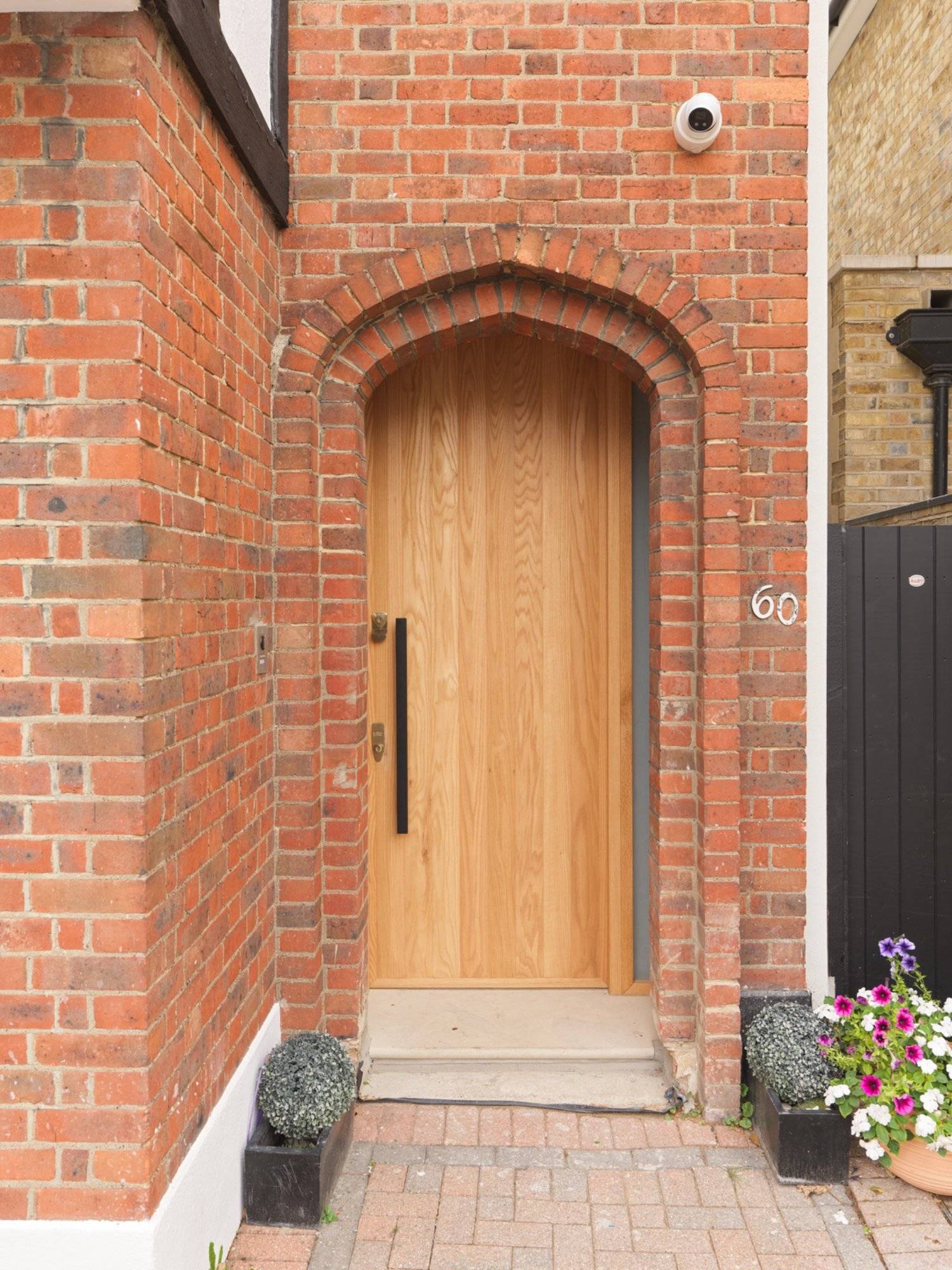 Arched front door entrance feature in red brickwork on a contemporary Clapham South property by Love Locations.