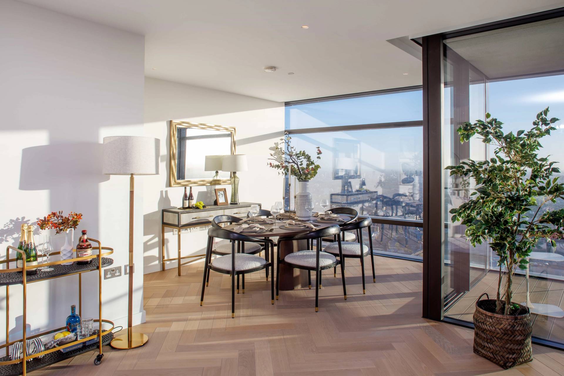 High-rise penthouse dining area featuring a round table, designer chairs, and floor-to-ceiling City of London skyline views, ideal for luxury tableware lookbooks, Love Locations EC2A.