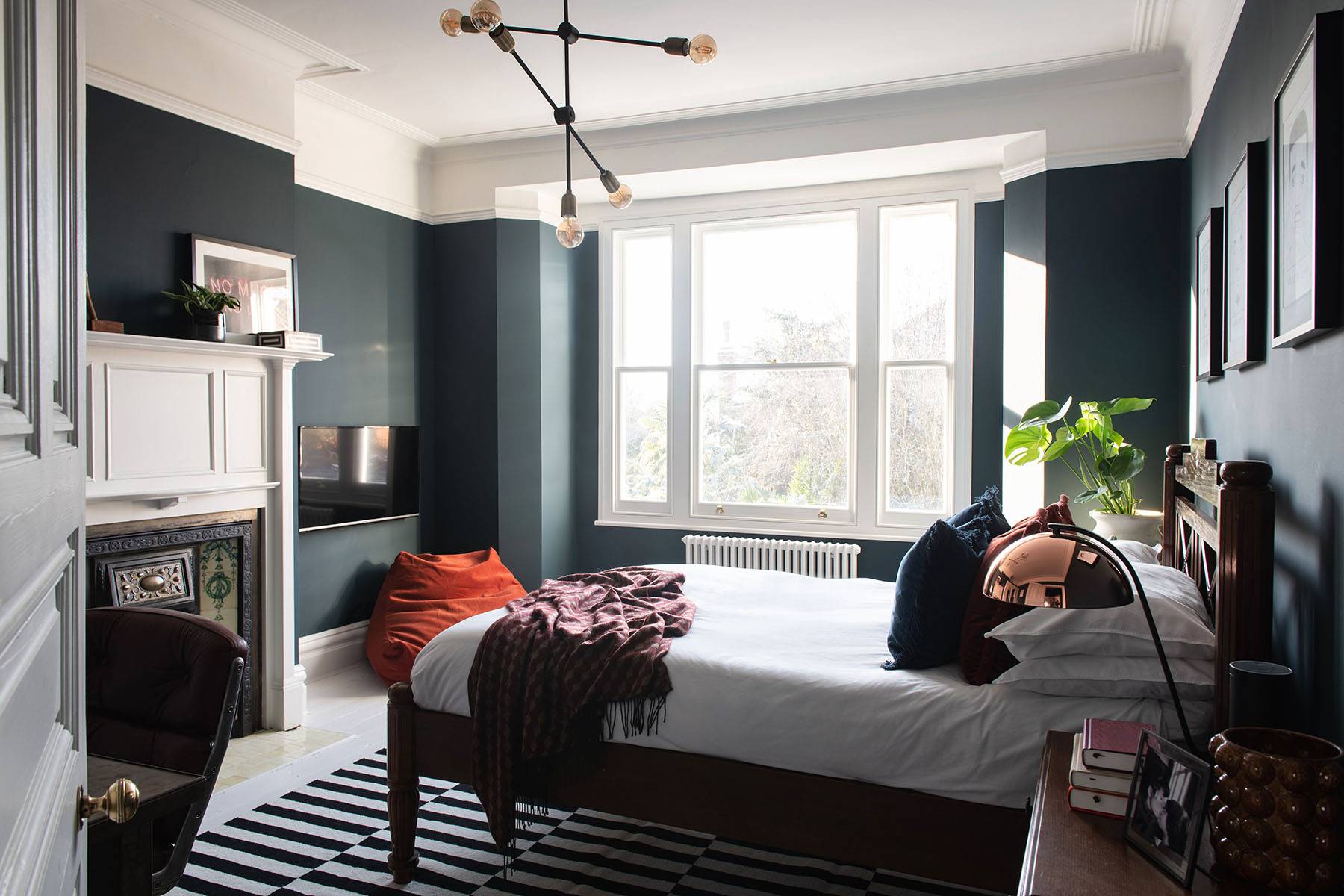 Dark teal bedroom featuring a period cast iron fireplace hearth and white painted mantelpiece, ideal for dramatic film scenes, Love Locations SW16.