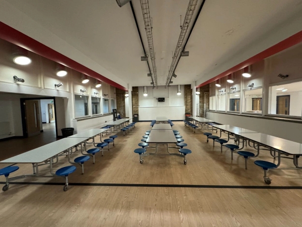 Love Locations school dining hall location Cockfosters EN4: Symmetric view of an institutional cafeteria with folding lunch tables and blue stools, ideal for school dinner scenes and TV commercials.