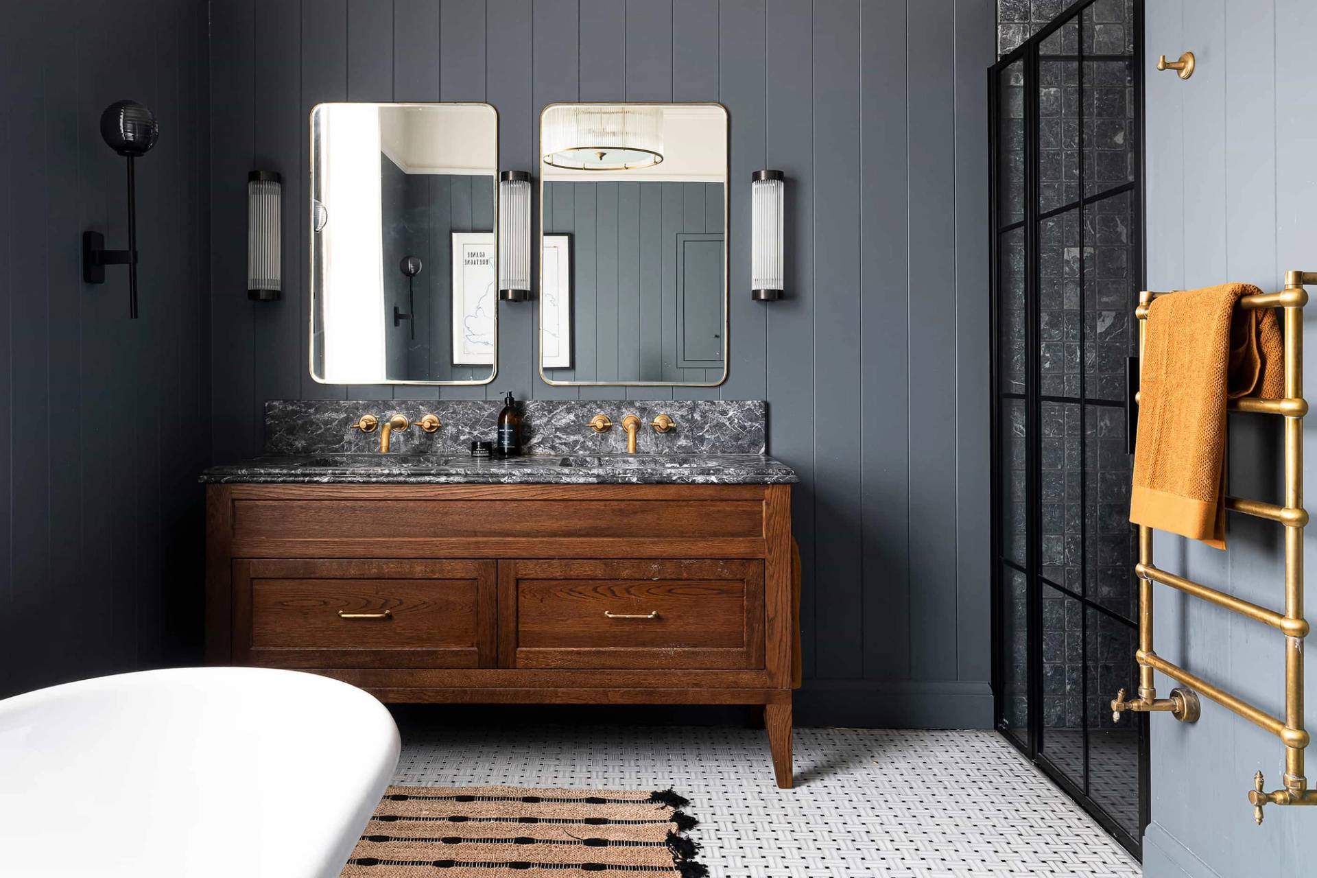 Double vanity unit with a vintage dark wood cabinet, marble sink top, twin mirrors, and dark grey panelled walls, Love Locations.