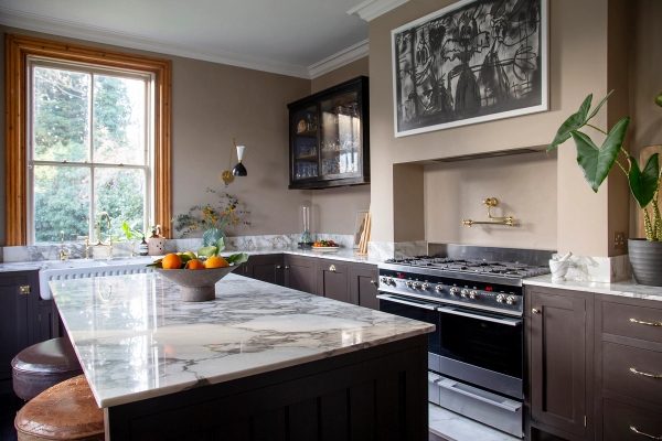 Contemporary kitchen location featuring dark wood cabinets, veined grey marble island counter, and Range cooker, Love Locations ME13.