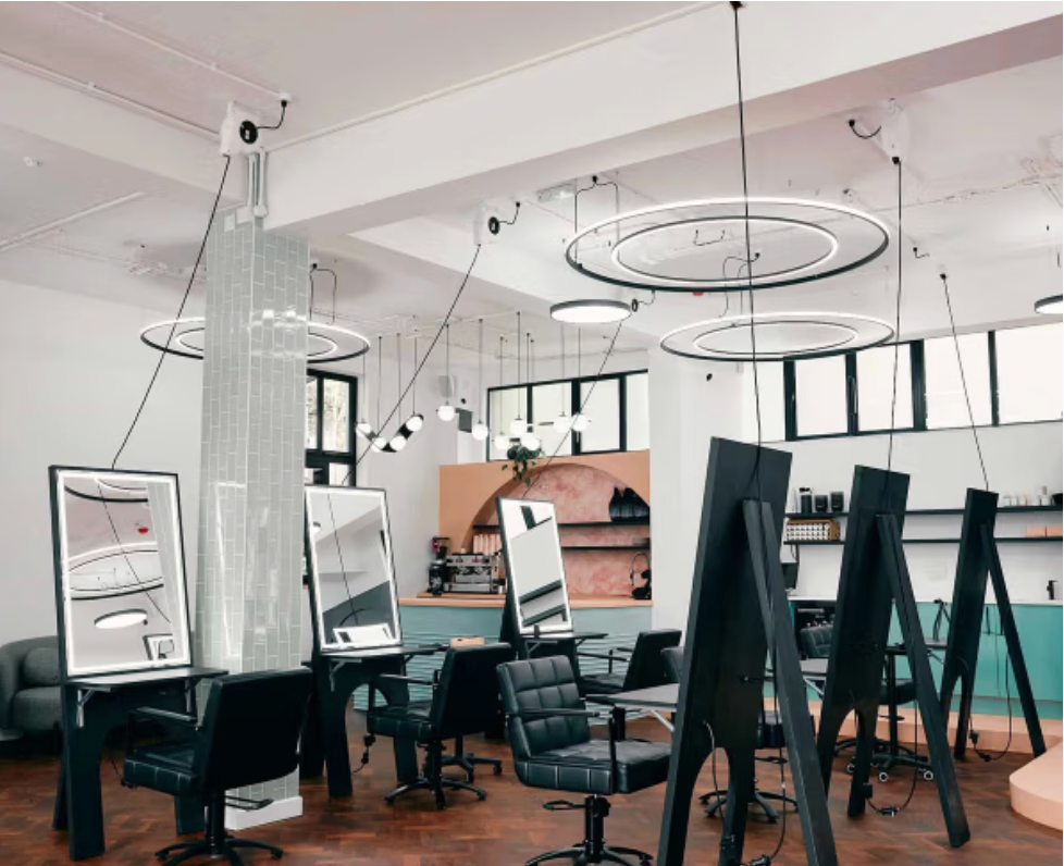 Modern open-plan event space with contemporary lighting and styling stations, suitable for Christmas brand events and private hire.