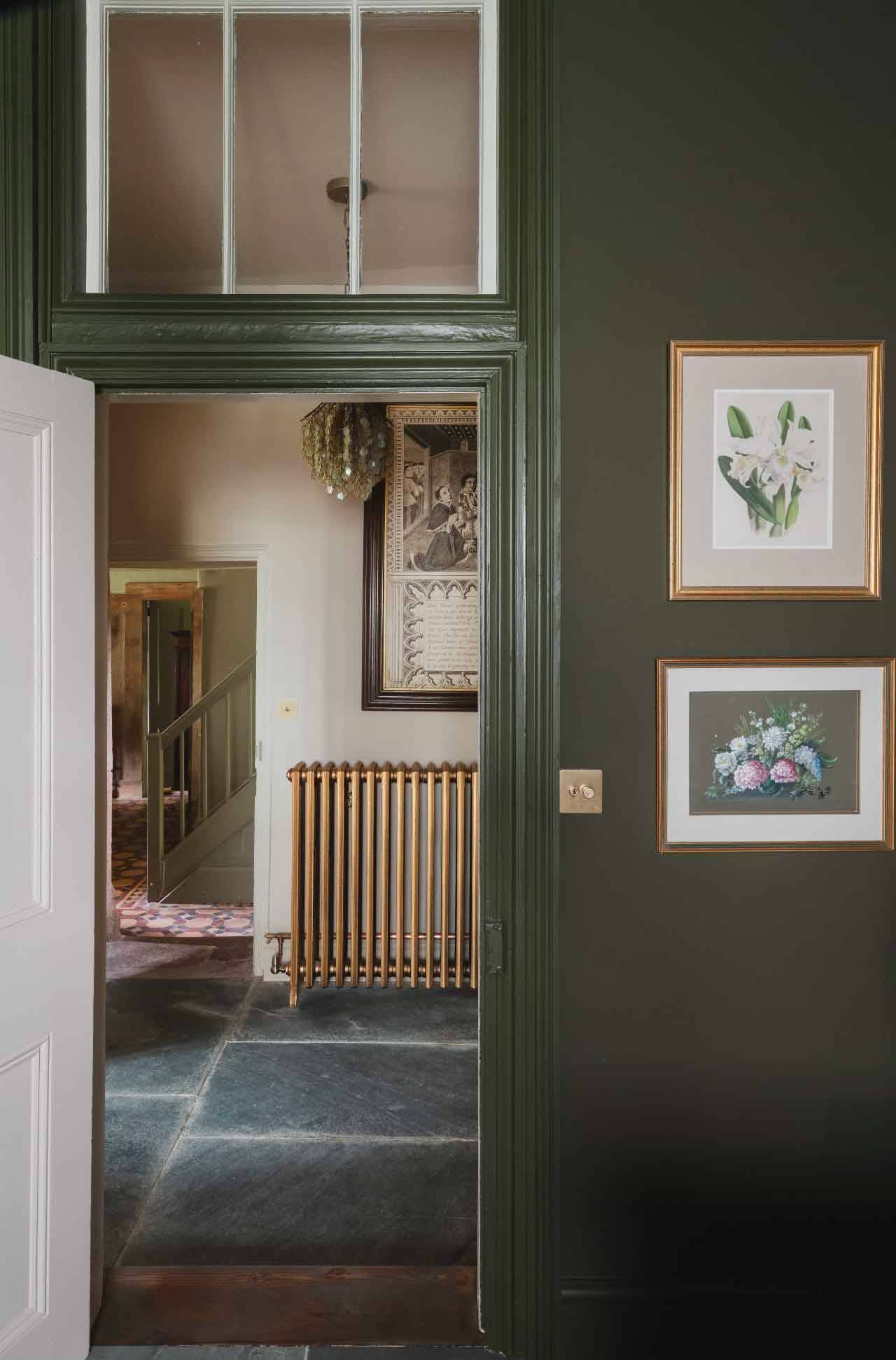 Olive green panelled doorway and flagstone hallway in a Grade II-listed manor house in Newquay Cornwall TR8 via Love Locations.