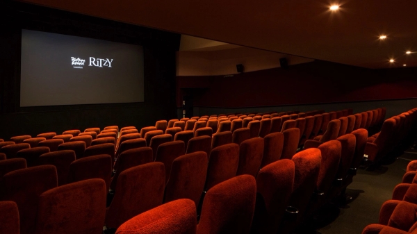 Side perspective shot highlighting rows of classic red velvet cinema seating and the widescreen projection display inside The Ritzy Screen 2 venue hire by Love Locations.