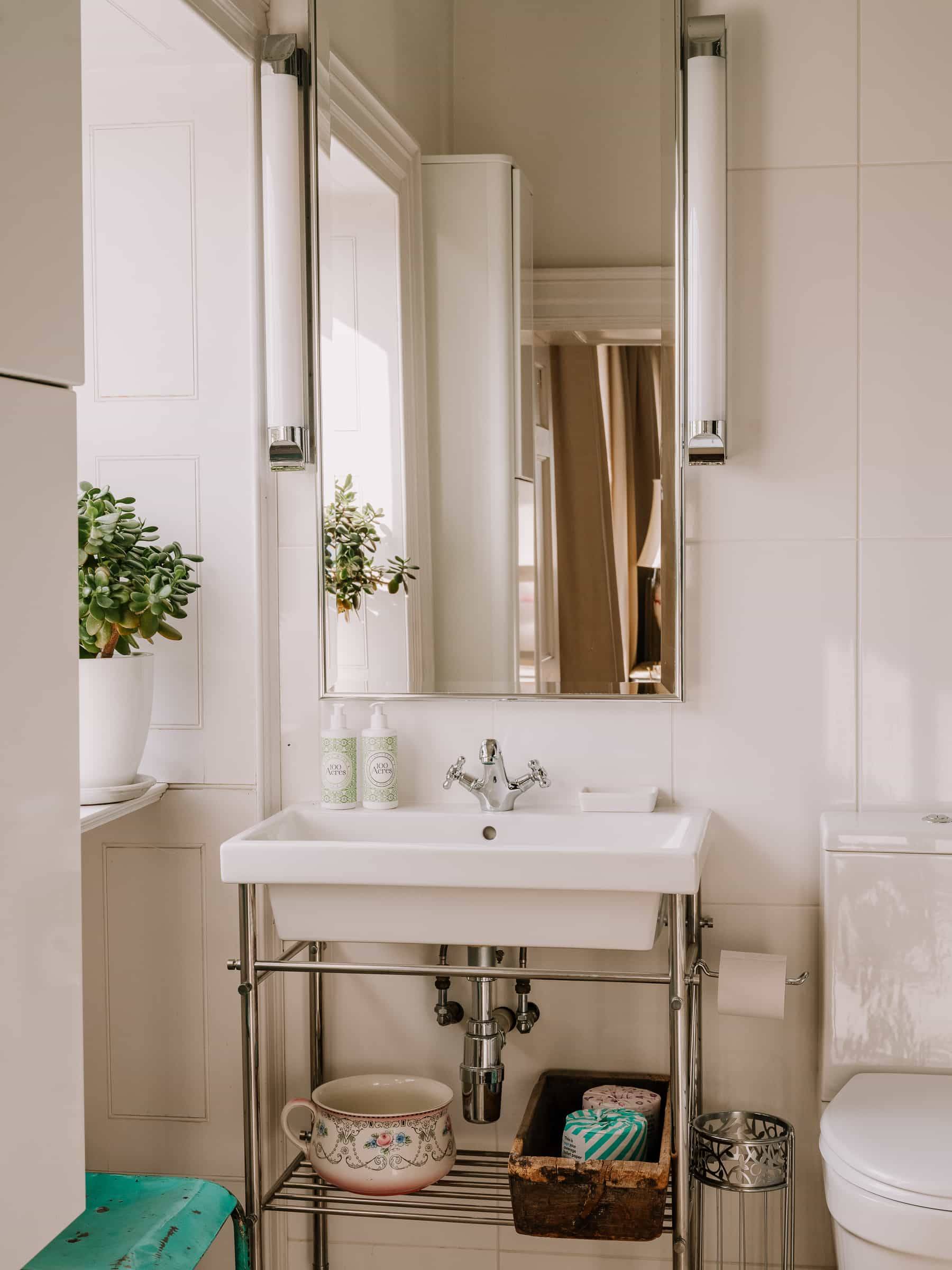 Sleek chrome console bathroom vanity with double vessel sinks and vertical wall lights, Love Locations RG42.