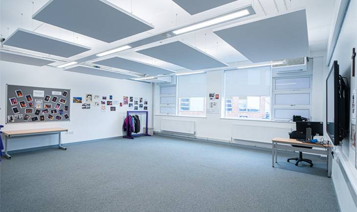 Minimalist open-plan school room photo location with acoustic ceiling baffle panels and tall glass windows by Love Locations.