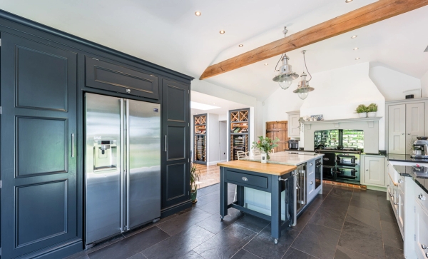 Luxury converted barn kitchen location with black cabinetry and a central marble island unit in Chelmsford, CM3 via Love Locations.