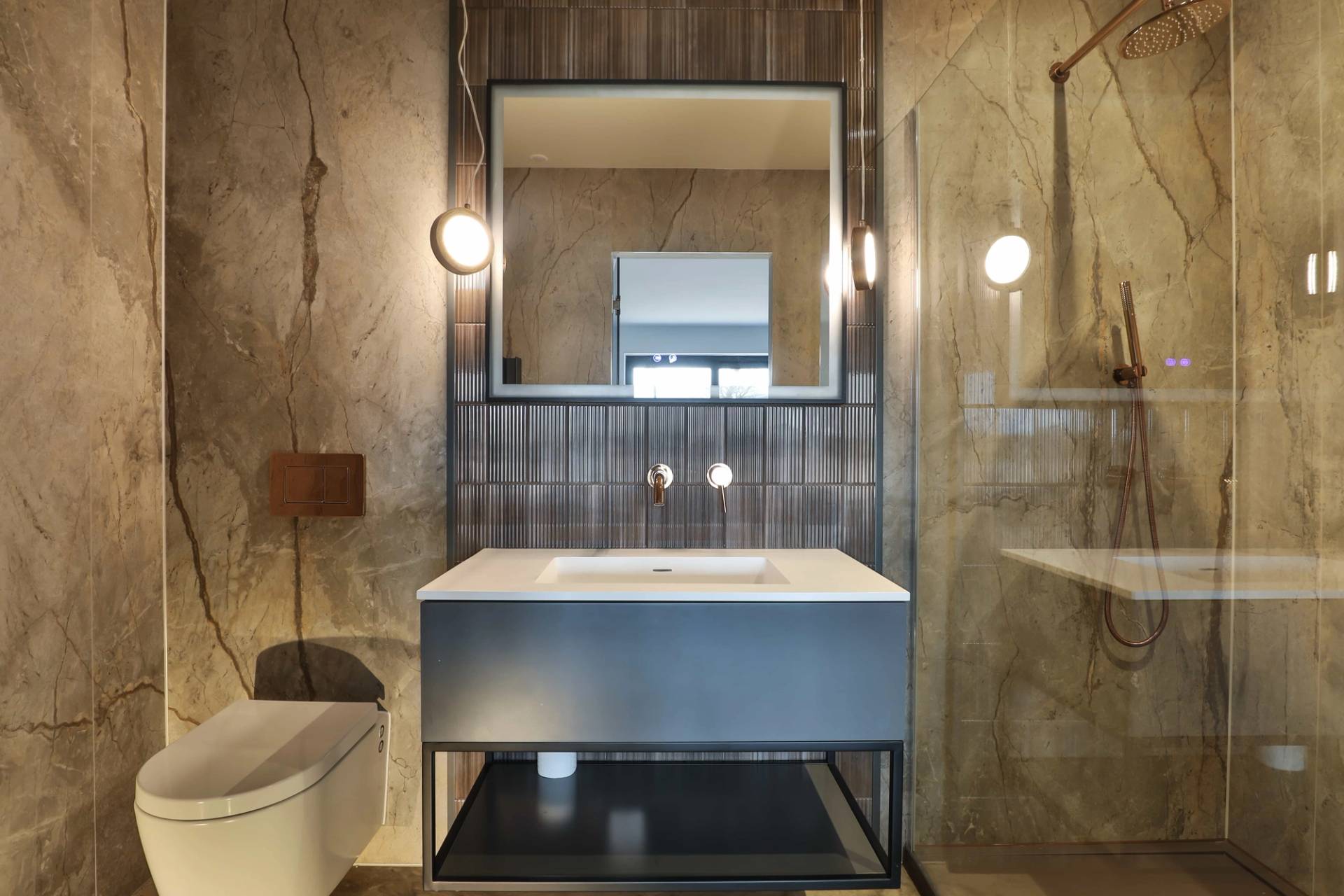 Luxury bathroom vanity setup with a dark blue floating cabinet, rectangular mirror, and brass fittings, Love Locations CV23.