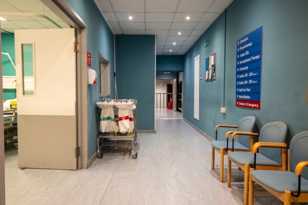 Hospital corridor location featuring medical trolley, blue painted walls, and patient seating for TV drama filming, Love Locations UB4.