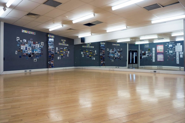 Love Locations dance studio shoot location Bristol BS7: Performing arts space featuring a polished wooden floor, corner mirrored walls, and black display boards, ideal for music videos and fitness ads.