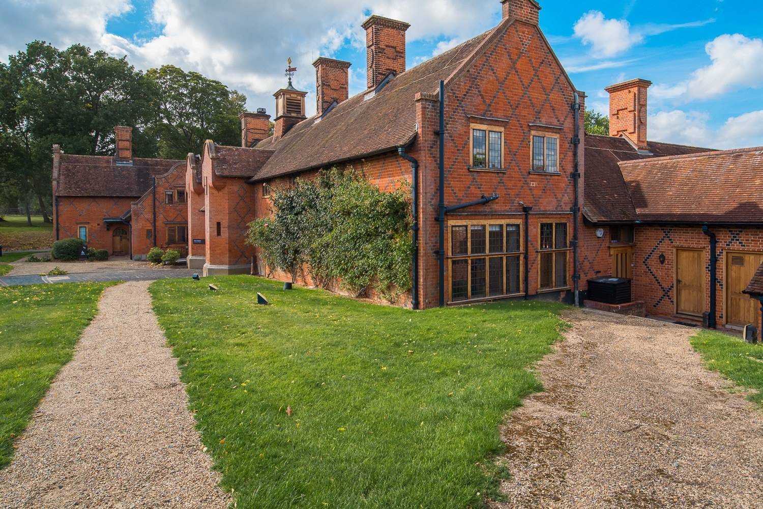 Brick outbuildings and manicured lawn gardens on a private Hertfordshire country estate by Love Locations.
