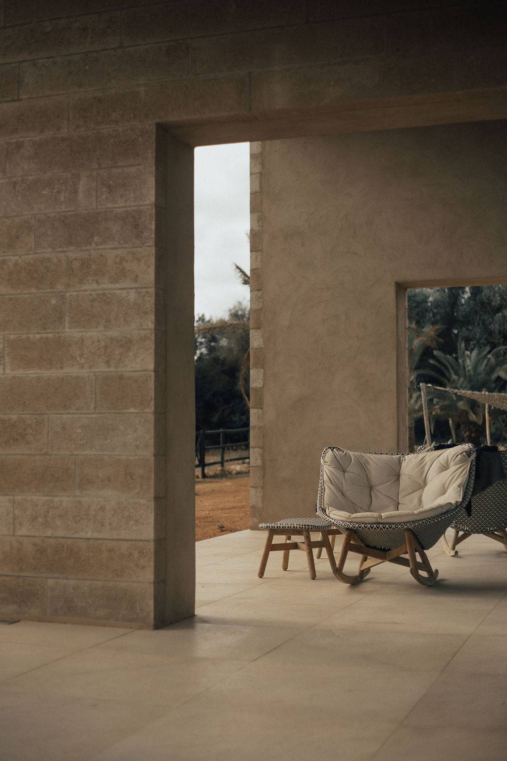 Shaded stone patio alcove set with comfortable outdoor lounge chair seating, Love Locations 07630.