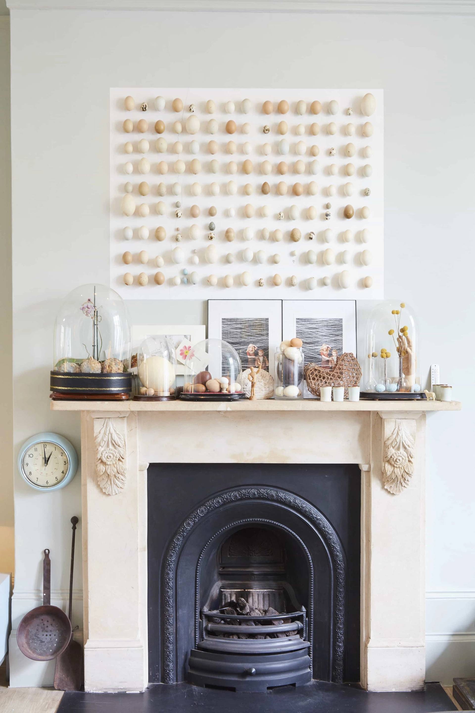 Close-up detail of a carved stone fireplace mantelpiece styled with trinkets and artwork in an Islington location home, Love Locations.