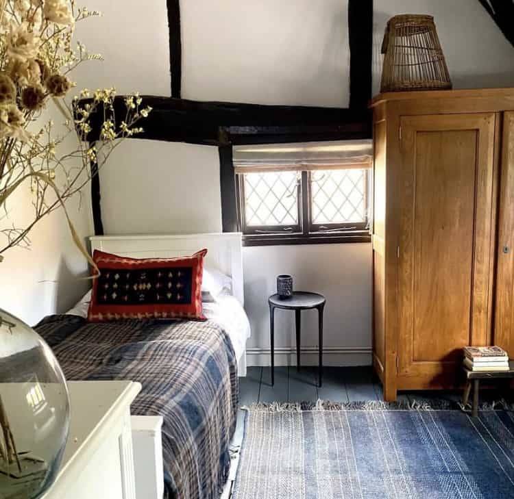 Rustic attic guest bedroom featuring single bedding, a wooden wardrobe, and traditional small window openings, Love Locations RG9.