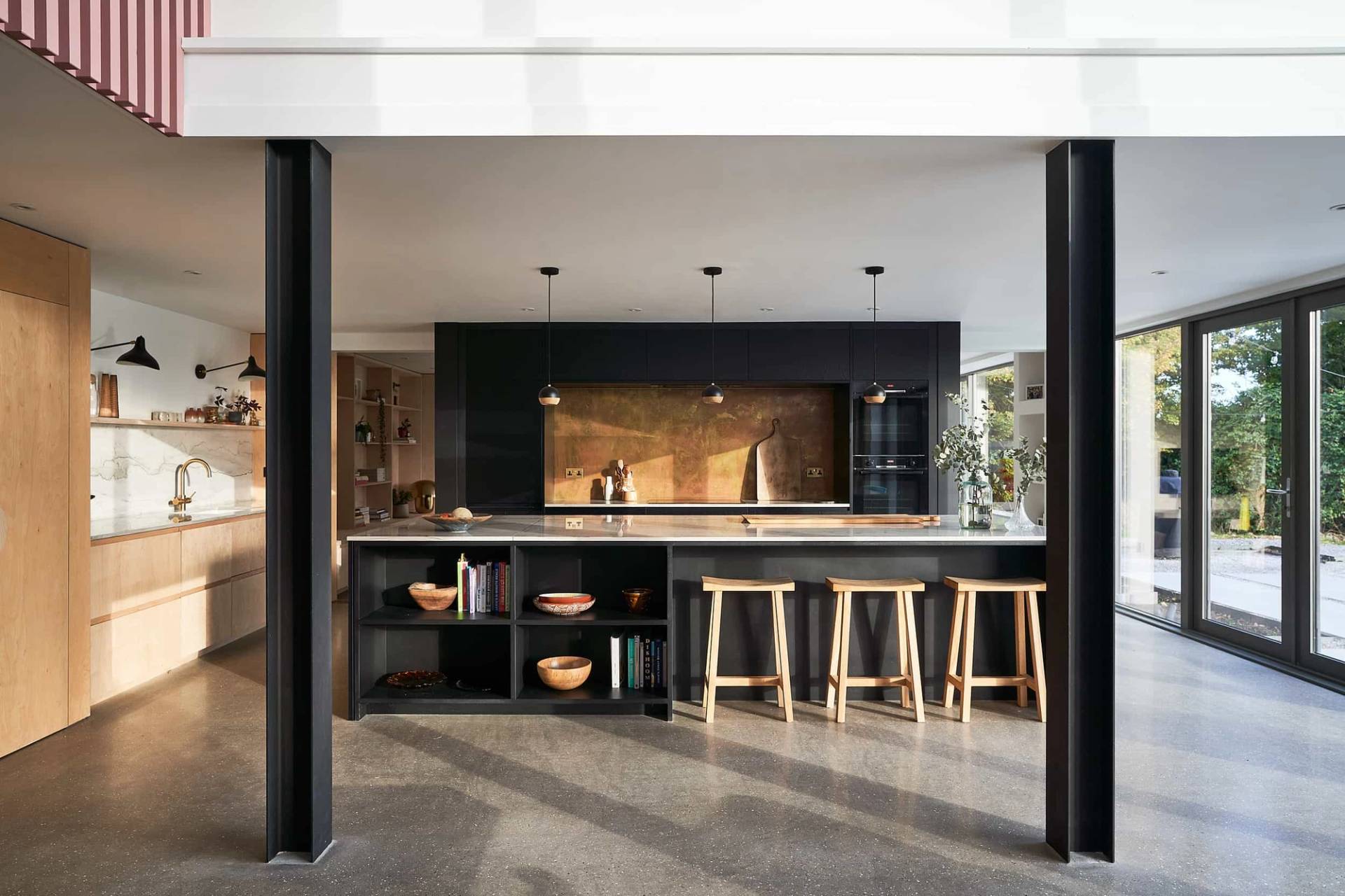 Modern barn conversion kitchen in IP30 featuring a dark charcoal island, marble counters, and bar seating, Love Locations Suffolk.