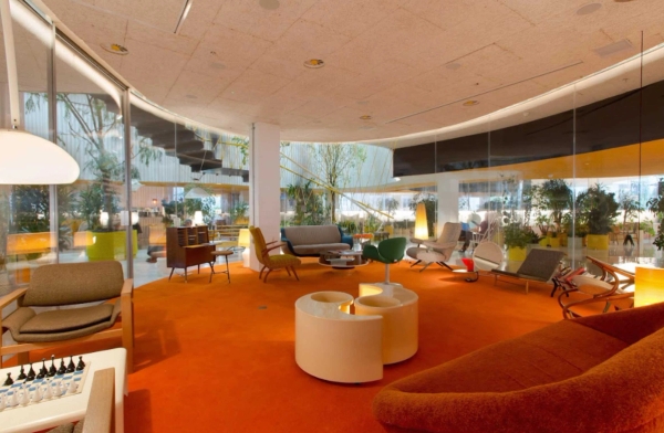 Contemporary circular study lounge with floor-to-ceiling windows and colourful seating in Whitechapel London – love locations