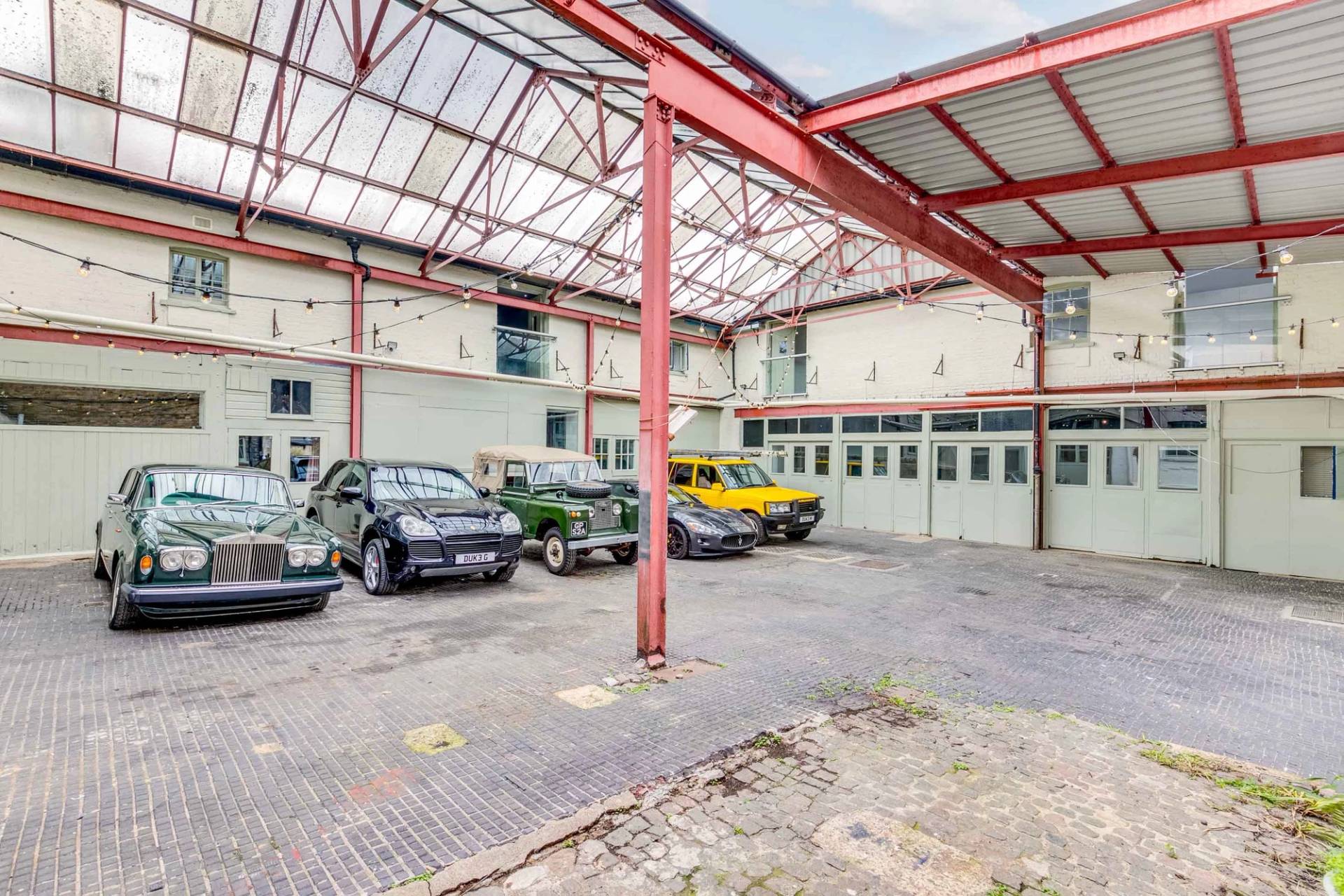 Industrial courtyard location space with vintage and classic cars parked for automotive editorial shoots, Love Locations.