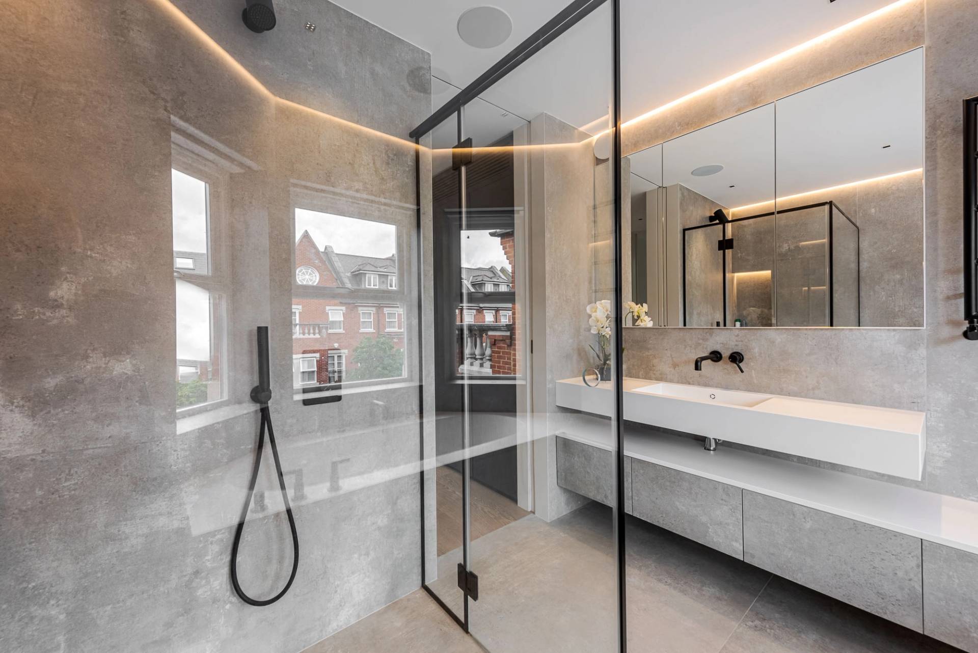 Ensuite shower room with frameless glass doors, grey marble wall tiles, and modern vanity, Love Locations SW11.