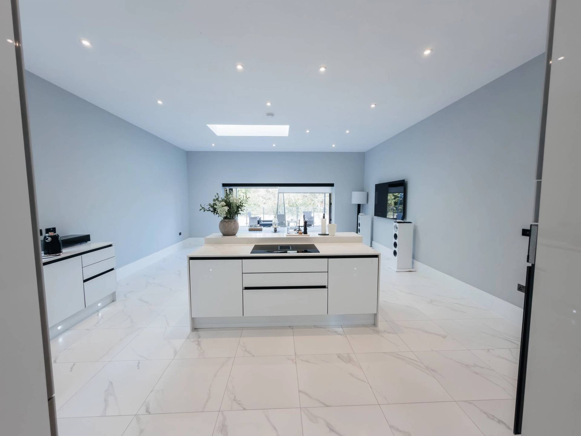 Modernist white kitchen location home for commercial filming in Barnet EN4 by Love Locations, highlighting clean architectural lines, central island, and abundant natural light.