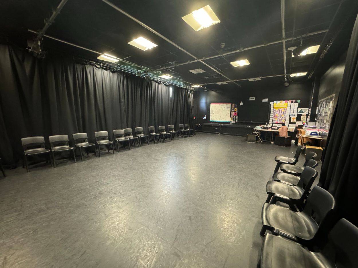 Multi-use performance studio film set featuring black curtains and perimeter chair arrangements from Love Locations.